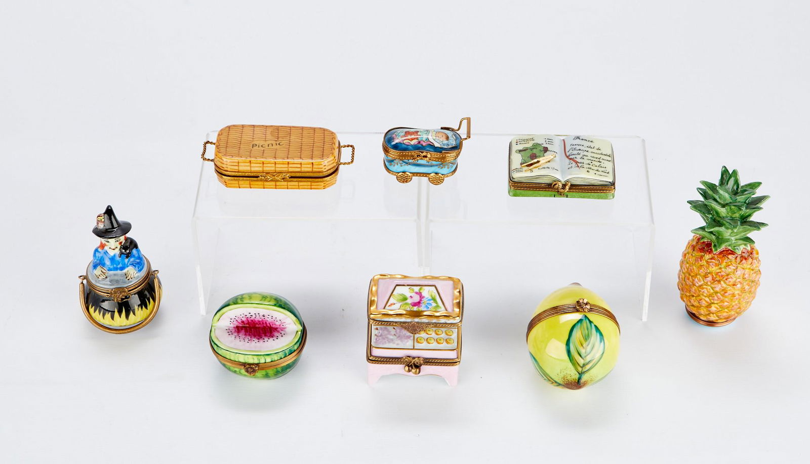 Grp: 8 French Limoges & Halcyon Porcelain Boxes: Limoges, France. Group of eight assorted hand painted porcelain pill boxes including: one lemon, additionally marked as a Chamar exclusive; one witch in a cauldron, initialed along the bottom with G.G