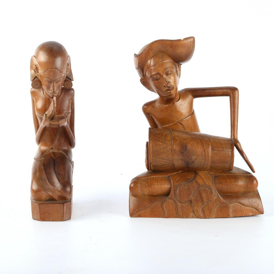 Attrib. Ida Bagus Njana Balinese Carvings: Group of two Balinese wooden carvings attributed to Ida Bagus Njana (Balinese, 1912-1985). One depicting a figure playing a drum, inscribed 5094 along the underside. The other depicting a kneeling fig