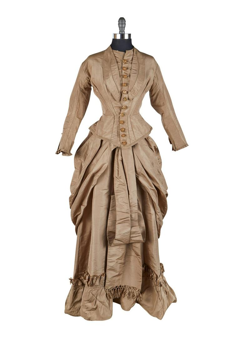 1880 Silk Skirt and Jacket: Two piece taupe dress or day suit with a silk skirt and jacket with a bustle, ca. 1880. With fringed decoration along the skirt hem and embroidered buttons. (Approximate) Jacket; Shoulder-to-shoulder:
