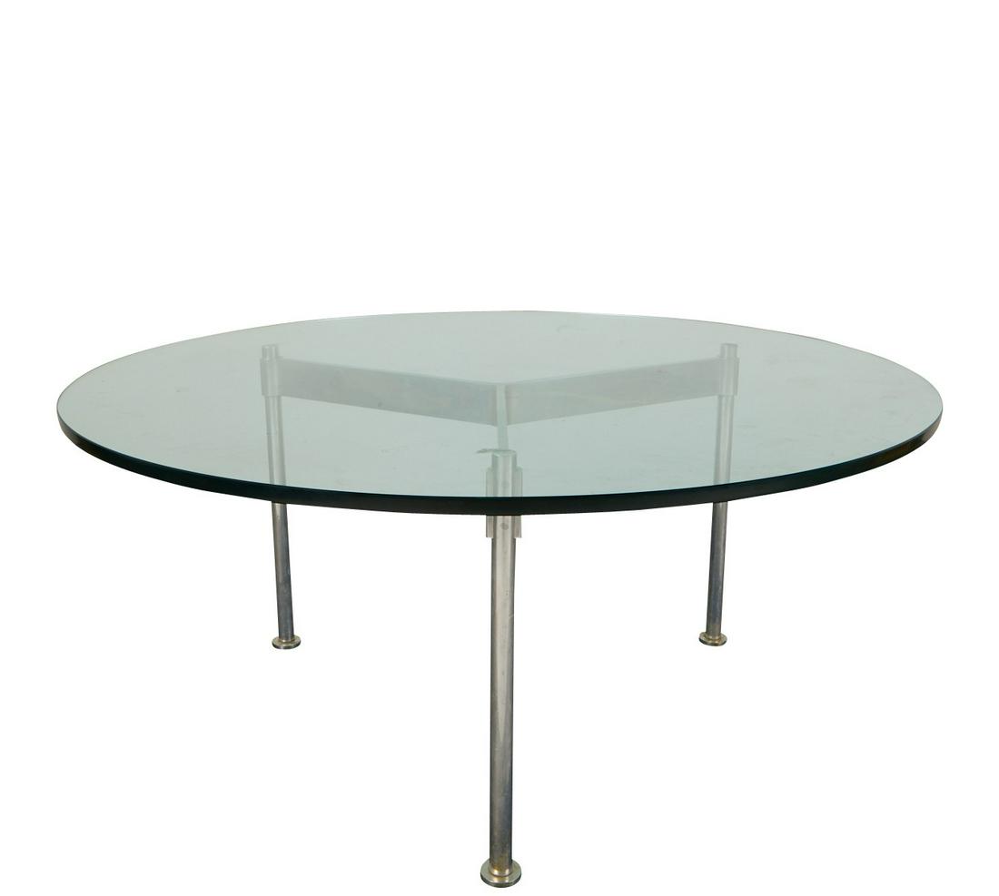 Ward Bennett MCM Glass & Chrome Coffee Table: Ward Bennett (American, 1917-2003). Mid-century modern glass top circular coffee table with chrome plated base with three legs. The base with three adjustable feet. Works by Bennett are held in the co