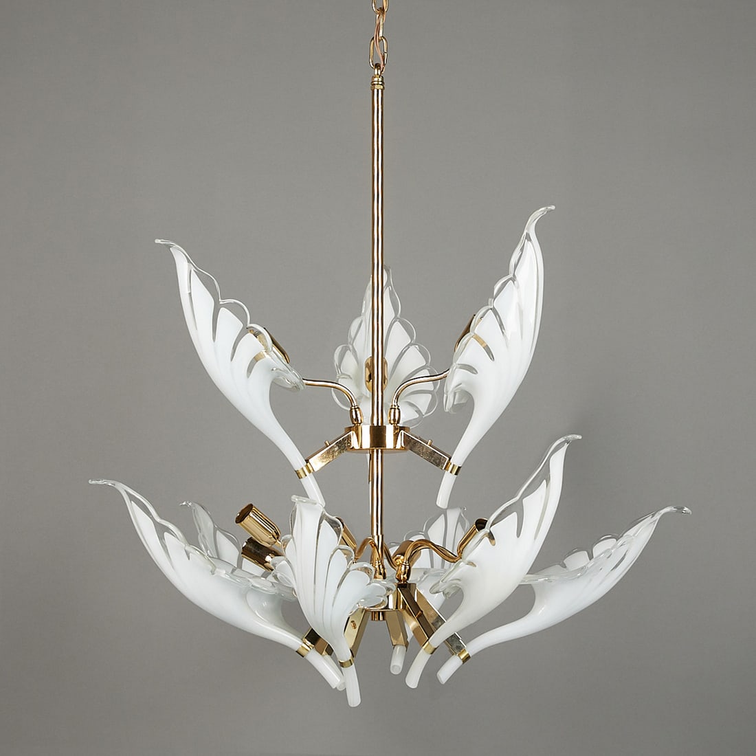 Franco Luce MCM Italian Murano 9 Arm Chandelier: Franco Luce, Italian. Mid-century Modern chandelier. With nine white and clear Murano glass sconces in the form of lilies and a brass frame. Two-tiered with three scones along the top and six along th