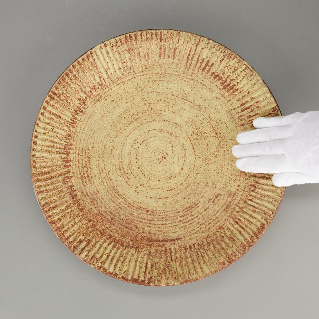 Laura Anderson Ceramic Charger 1946: Laura Anderson (American, 1902-1999). Large studio ceramic charger or plate, 1946. Stoneware with a white slip and with a titanium matte glaze over the top. The rim with a ridged pattern. Incised sign
