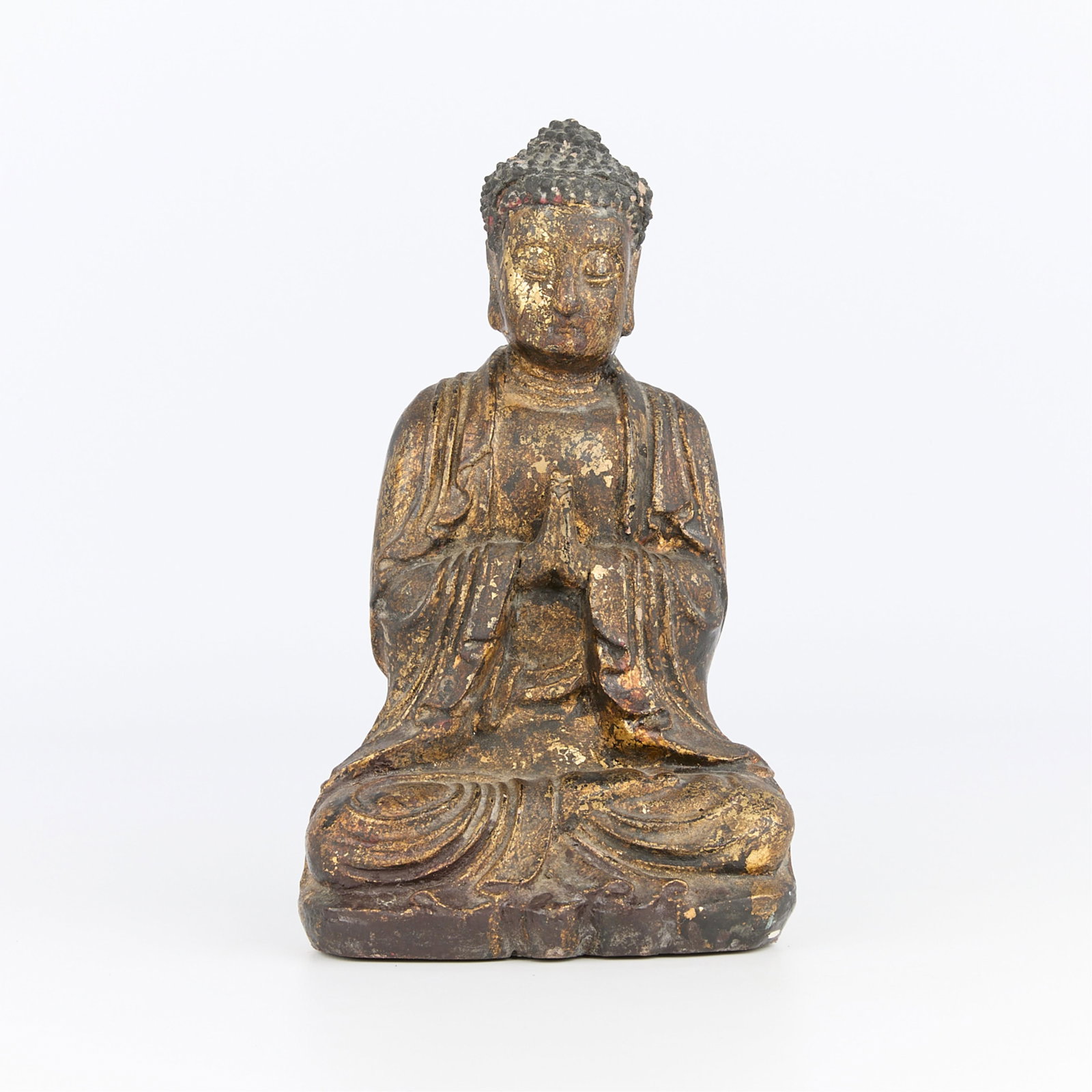 Late Qing Chinese Wooden Buddha with Gilt Surface: Chinese late Qing dynasty wooden buddha figure depicted in a cross-legged, seated position with praying hands, a solemn expression, and hair drawn in a bun atop his head. With gilt surface. Height: 11