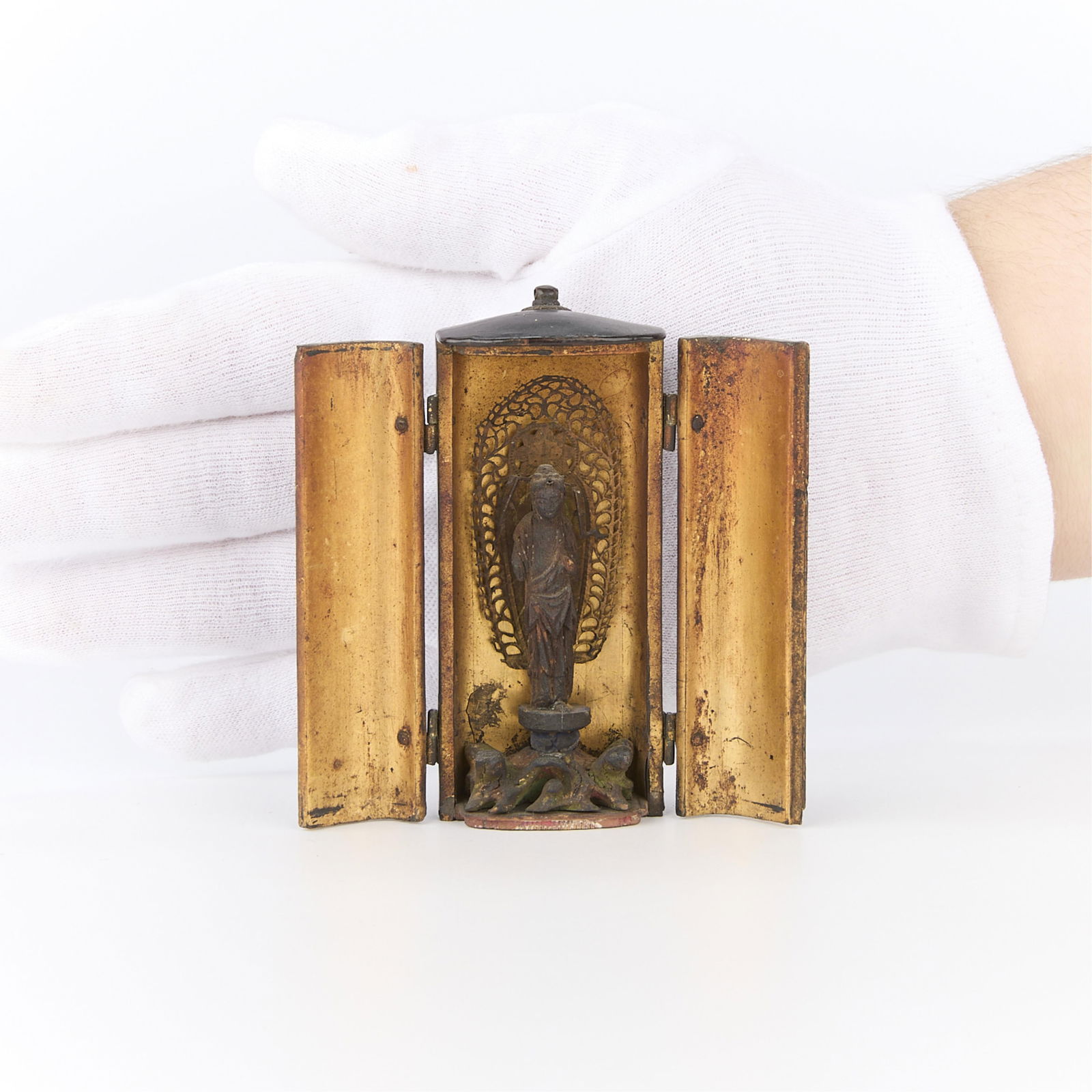 Small 19th c. Japanese Buddhist Zushi Shrine: Small Japanese 19th century zushi shrine with gilt characters along the front of the doors of the black lacquer case, a gilt interior, and a hand carved Buddhist figure within the case.Height: 3 1/2 i