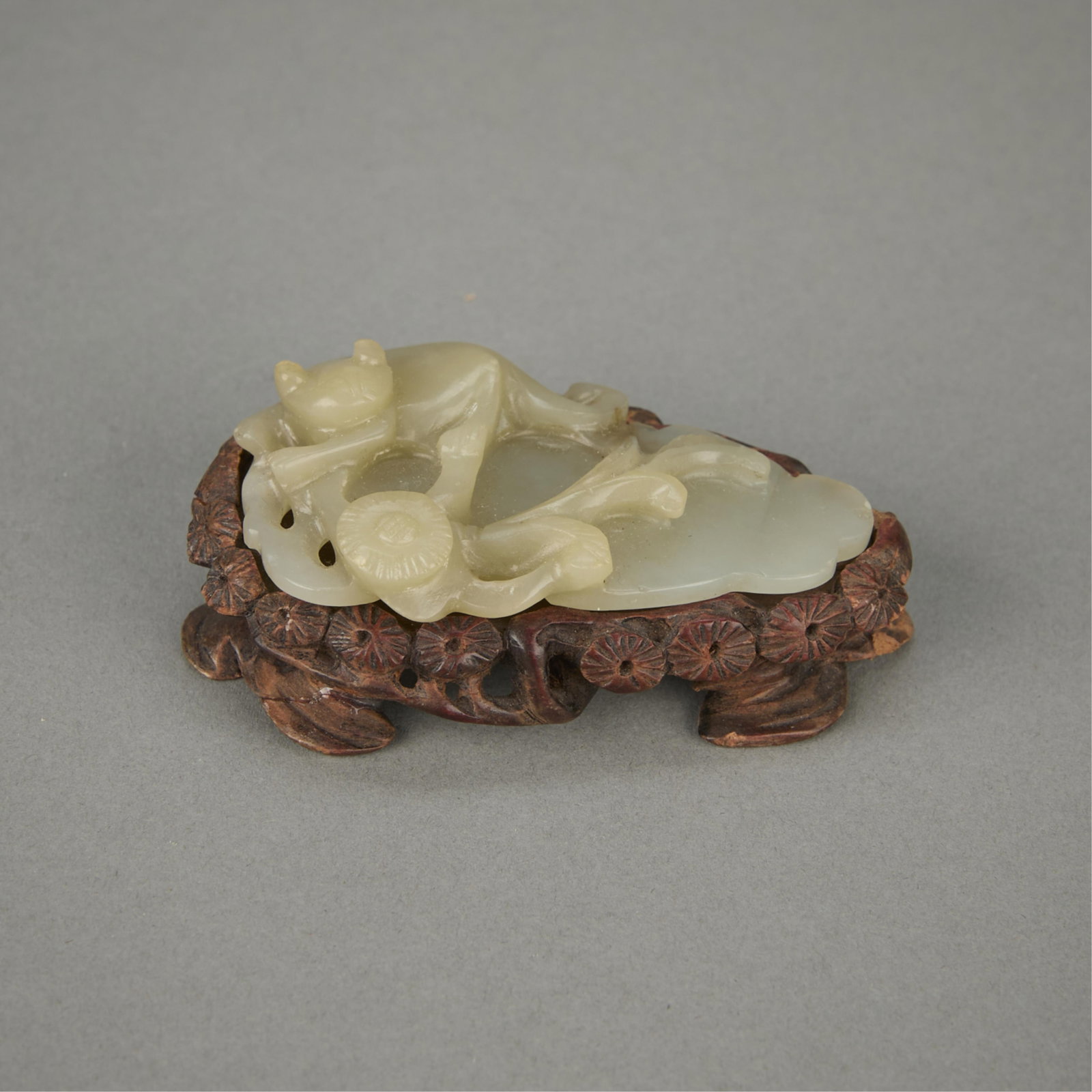 Chinese Qing Carved Jade Cat & Flowers: Antique Chinese Qing dynasty celadon jade carved in the form of a cat and flower with an original carved wooden stand. (Without stand) Height: 1/2 in x width: 1 3/4 in x depth: 2 3/4 in. Weight: 29 g.