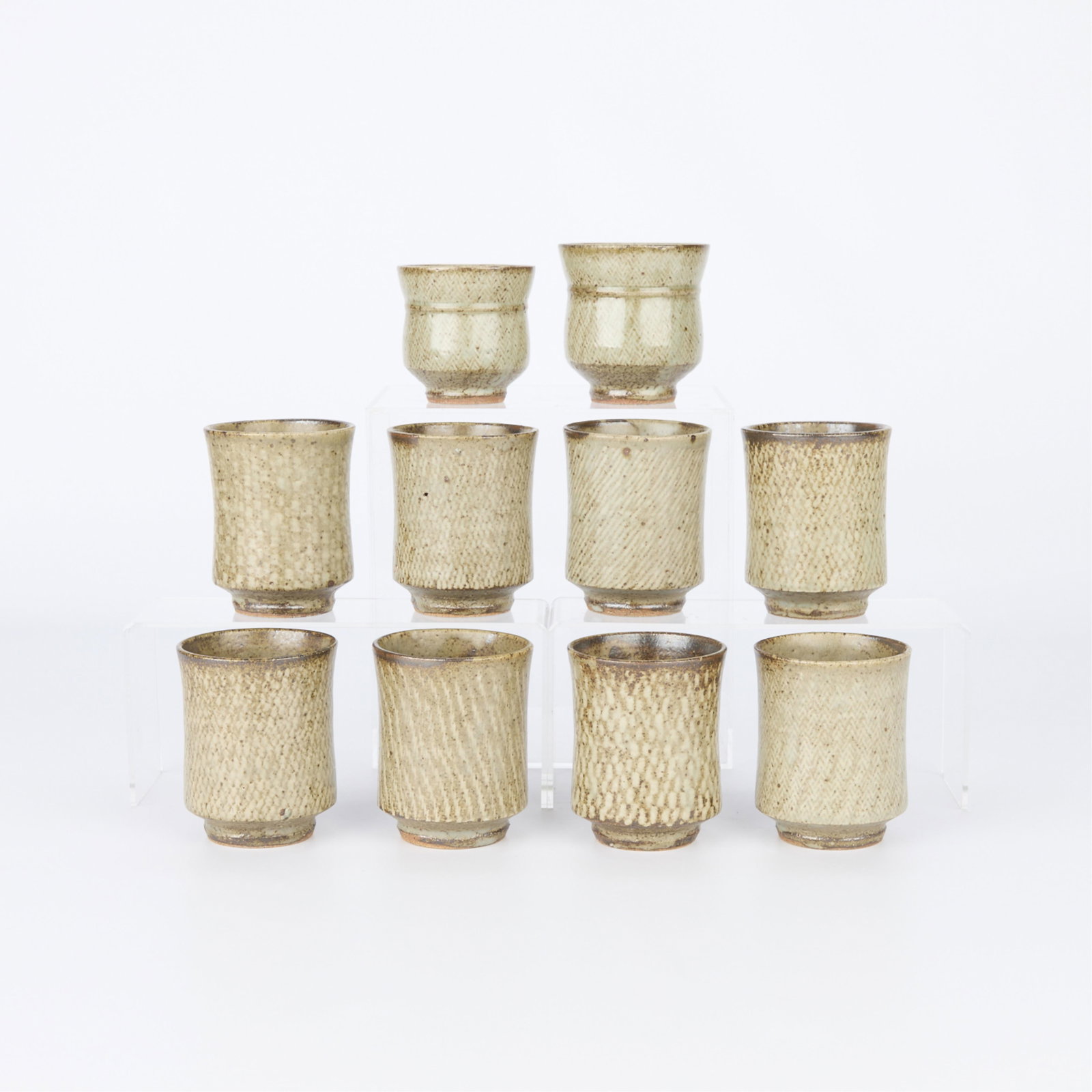 10 Tatsuzo Shimaoka Ceramic Tea Bowl Cups: Tatsuzo Shimaoka (Japanese, 1919-2007). Group of ten studio ceramic chawan tea bowls or yunomi cups, 20th century. Stoneware of an iron-saturate, Mashiko clay body. With an iron-free ash celadon glaze