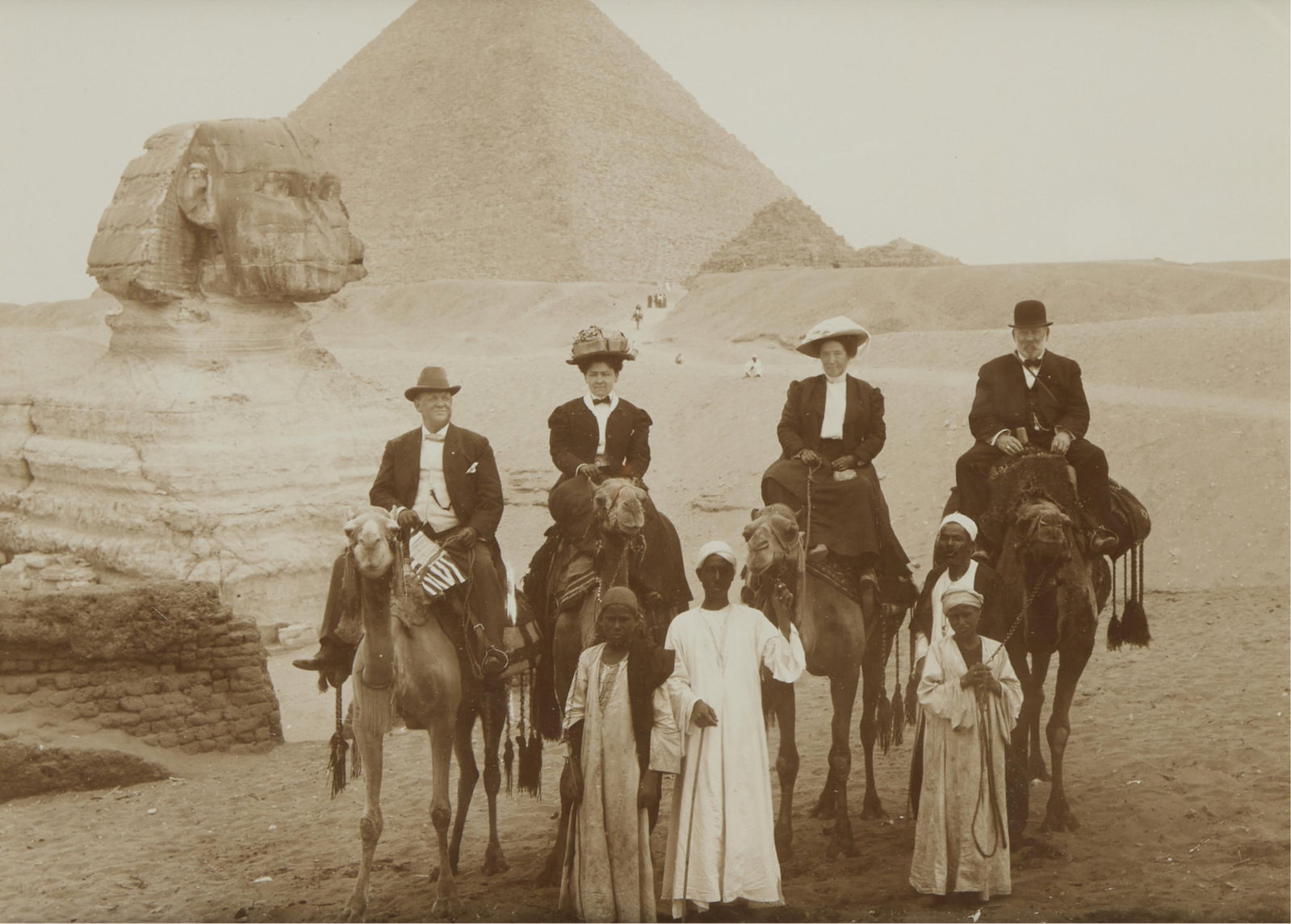 19th c. Albumen of Giza Sphinx & Pyramid: Late 19th century albumen photograph print depicting four figures atop camels posing in front of the Great Sphinx and the Great Pyramid of Giza. Lot Essay: These 1855-1900s albumen photographs of &quo