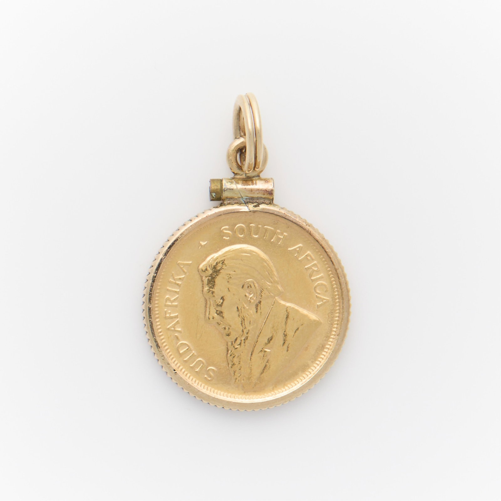 1/10 oz Fine Gold Krugerrand Pendant: 1980 1/10 Krugerrand set in a 12k gold filled pendant frame. The Krugerrand obverse marked Suid-Afrika South Africa" with the figure of Paul Kruger in profile. The reverse marked "1/20 Kruge
