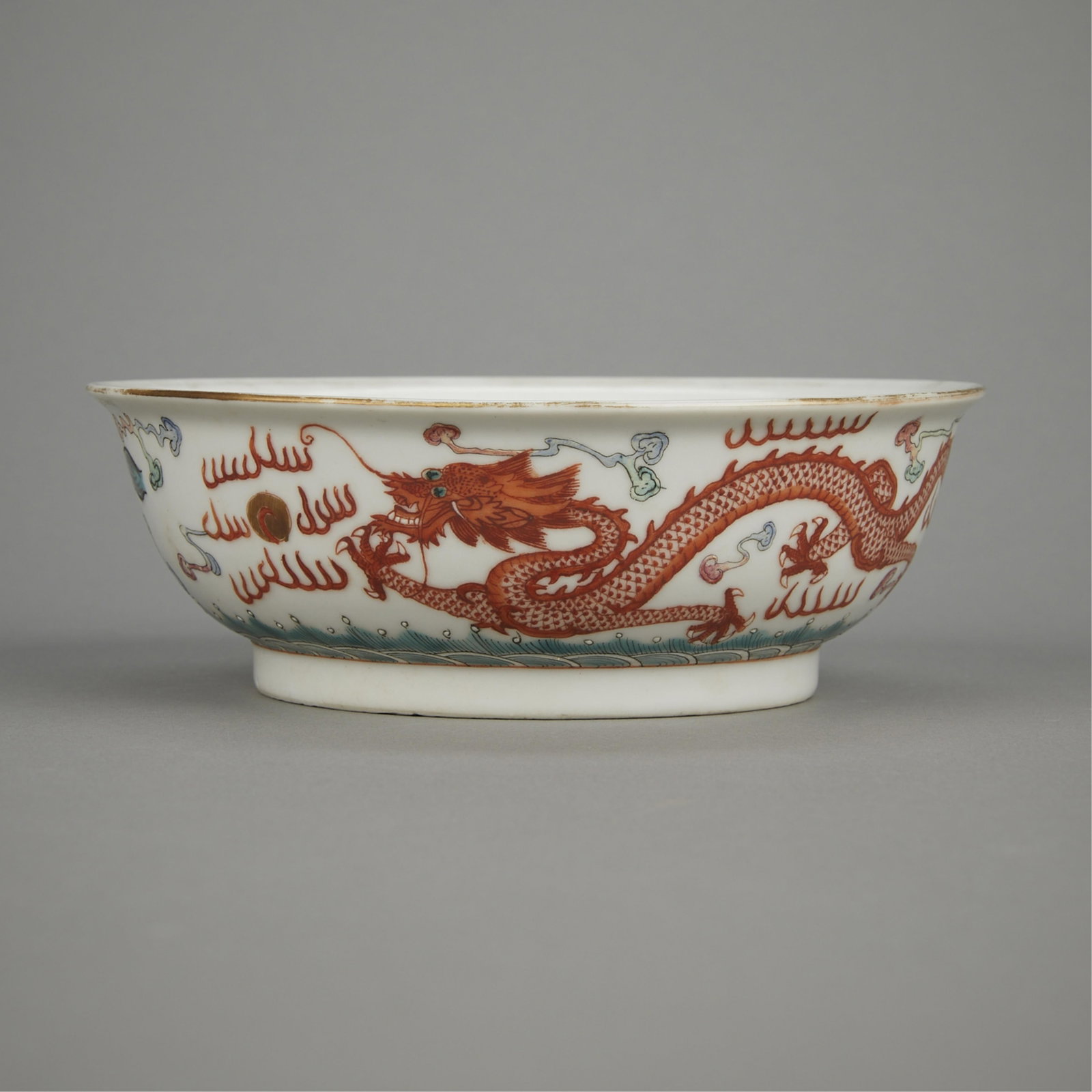 Chinese Qing Dragon Porcelain Bowl: Chinese Qing porcelain bowl decorated along the sides with a phoenix flying towards a rising sun and a dragon chasing a flaming pearl. Painted with a four-character mark along the underside. Height: 2