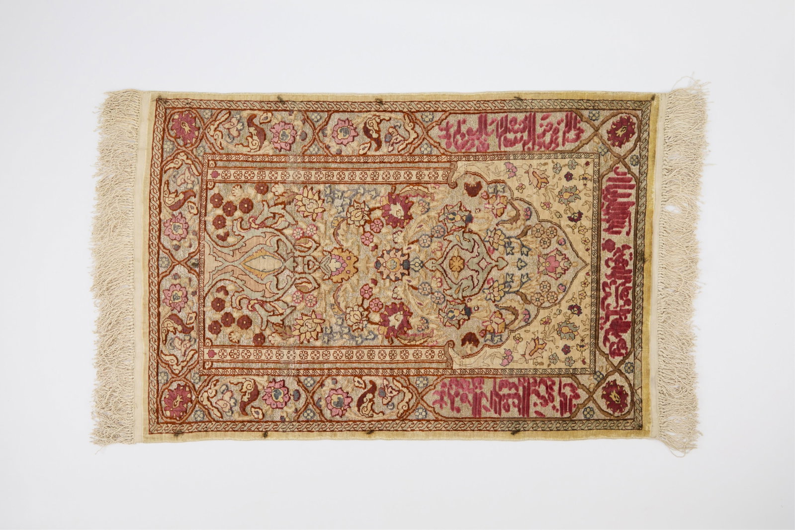 Small Persian Kerman Rug 3' x 1'8": Persian silk rug, possibly Kerman, with silver-wrapped threads and fringe. (Incl. fringe) length: 3 ft x width: 1 ft 8 1/2 in.