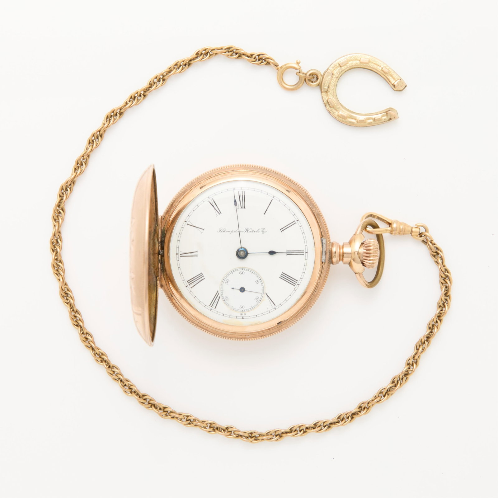 Hampden Gold Filled Pocket Watch: Hampden Watch Co., United States. One hunter pocket watch. Gold filled hunter case with engraved foliate and floral details. White dial marked Hampden Watch Co. with Roman hour markers, sub-seconds di