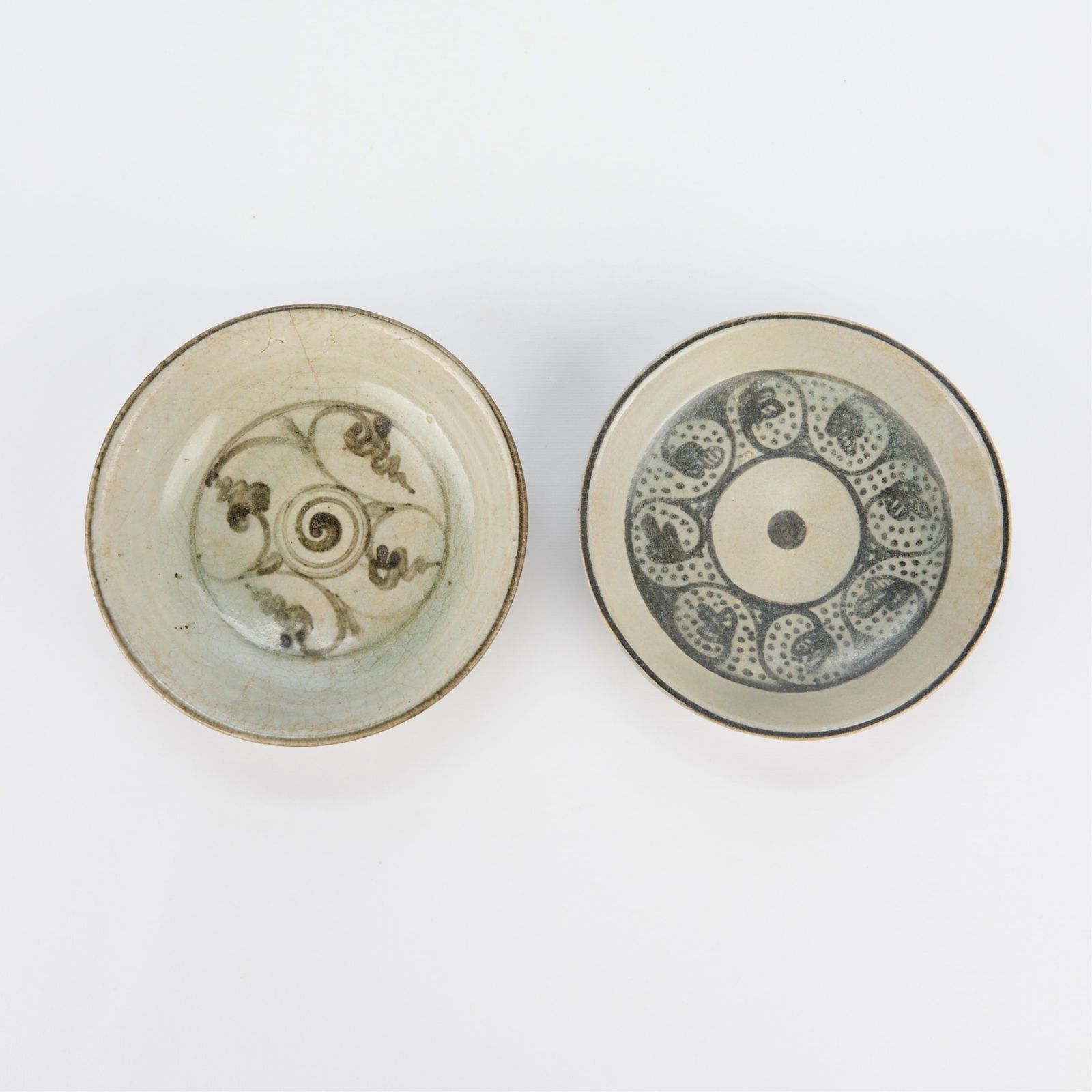 2 Thai Sukhothai Stoneware Ceramic Dishes: Group of two Thai Sukhothai stoneware shallow bowls, 14th-16th c. Both with swirled geometric motifs.Provenance: From the Distinguished Personal Collection of Dr. Robert Jacobsen.(Small) Height: 1 1/4