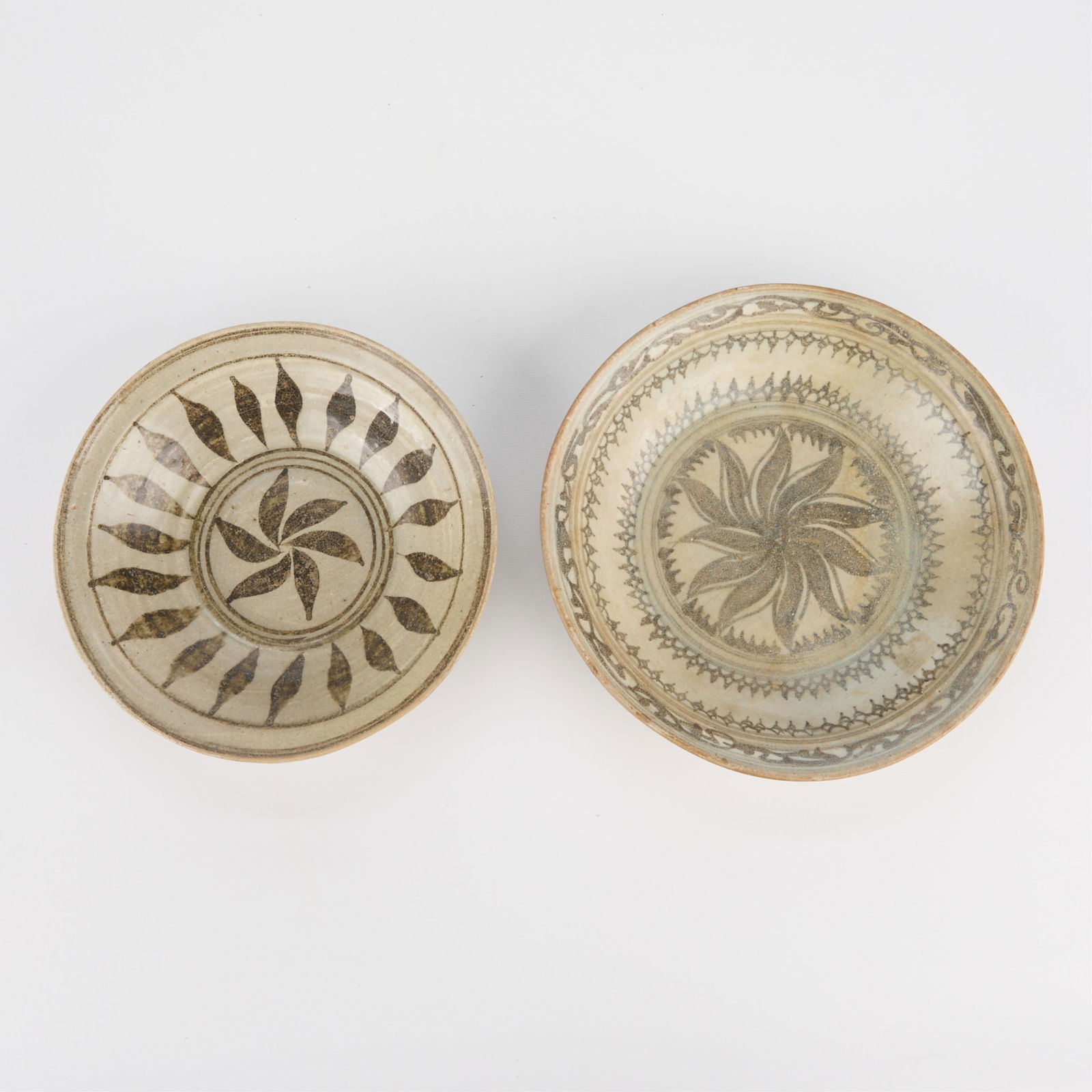 2 Thai Kalong Pinhweel Floral Stoneware Dishes: Group of two Thai Kalong stoneware dishes, 14th-16th c. Both with pinwheel or floral motifs.Provenance: From the Distinguished Personal Collection of Dr. Robert Jacobsen.(Small) Height: 1 3/4 in x dia