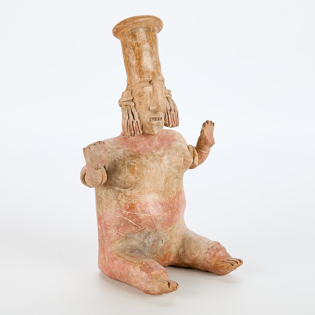 Jalisco Pre-Columbian Seated Female Figure: Jalisco pre-Columbian pottery in the form of a seated female figure retaining some of the red pigment, ca. 300 BCE-300 CE. Provenance: By repute from the Bell family Collection (known for their contri