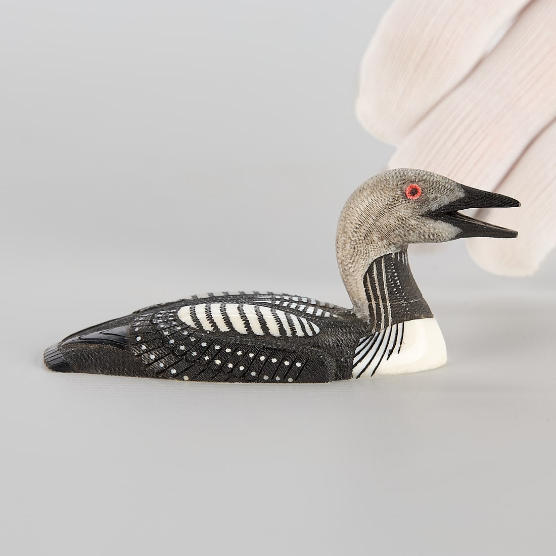 Larry Mayac "Arctic Loon" Carving 1999: Larry Mayac (Inupiaq, 20th/21st century). Carved walrus scrimshaw titled "Arctic Loon," 1999. Incised signature, title, and date along the underside. Height: 1 1/2 in x width: 3 1/4 in x dep