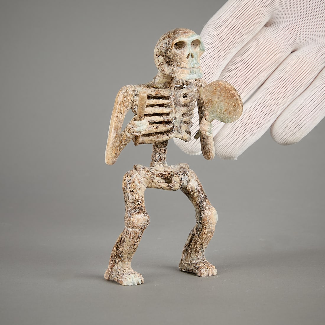 Inuit Skeleton Shaman Carving: Inuit carved bone sculpture of a skeleton shaman holding a drum and drum beater. Unsigned.Provenance: Heard Museum, Arizona; Private Collection, New York.Height: 5 1/2 in x width: 3 in x depth: 2 1/2