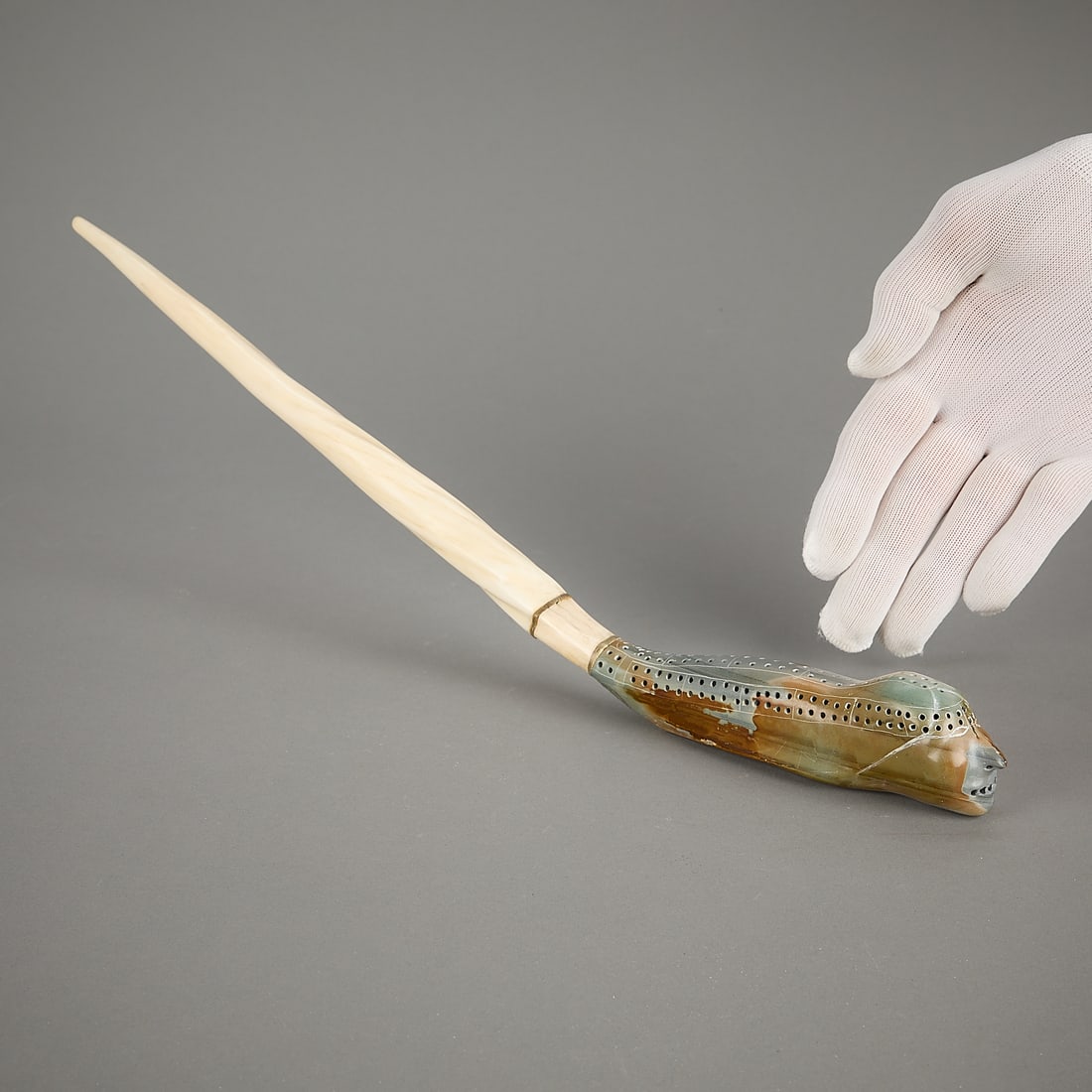 Leah Olatitaq Kalluk Cribbage Board: Leah Olatitaq Kalluk, Inuit. Cribbage board carved as a sotne transformation figure, morphing back into a narwhal tusk. Without pegs. Signed in Roman and dated 1978 along the base.Provenance: Heard Mu