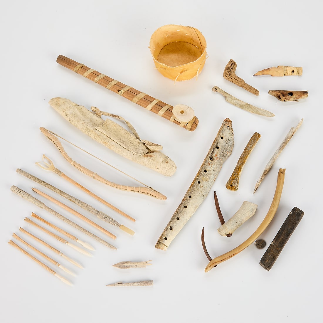 Misc. Inuit Tool Lot - Spence Bay: Miscellaneous lot of Inuit tools and implements including:A wooden, hide and organic material pipe.A piece of bone with several drilled holes.Four spear points in wood, bone and organic material.One w