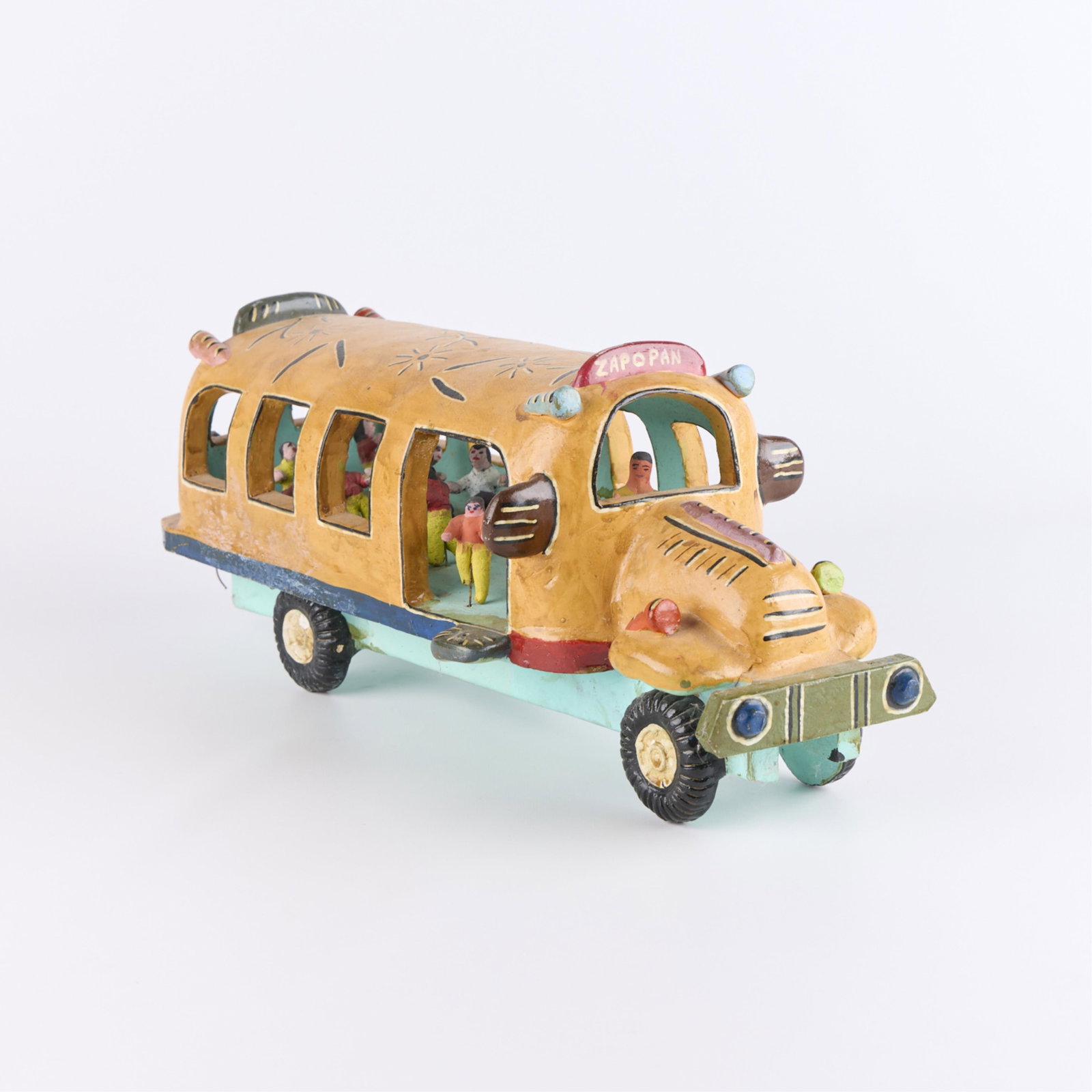 Candelario Medrano Tonala Folk Art Pottery Bus: Candelario Medrano (Mexican, 1918-1986). Vintage folk art painted and burnished (brunido) Tonala "Tlaquepaque" style pottery sculpture in the form of a colorful school bus with miniature stu