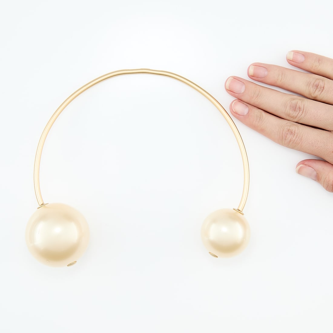 Chanel Faux Pearl Collar: Large Chanel faux pearl collar comprised of a rigid gold tone collar terminating in a 2 inch diameter faux pearl and a 1 inch diameter faux pearl. Marked Chanel Paris along the back. With large velvet