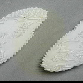 Modern Chinese Carved White Jade Plaque: Chinese modern carved white jade plaque depicting a figure along one side and branches of blossoming floral forms along the reverse.Height: 2 in x width: 1 1/2 in x depth: 1/4 in. Weight: 24.4 g.
