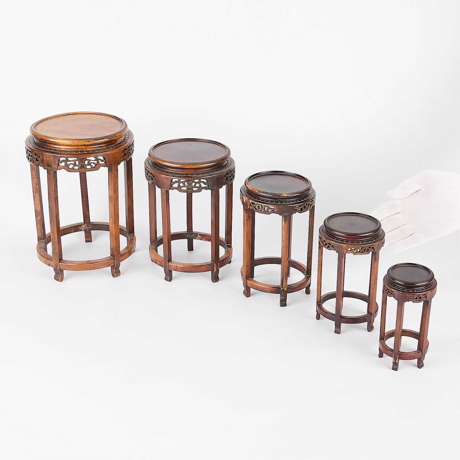 Set 5 Chinese Carved Wood Nesting Plant Stands: Set of five Chinese wooden nesting plant stands. Each with rounded form and delicately pierced skirts.Height ranges from 6 in to 10 1/2 in; diameter ranges from 3 1/4 in to 7 in.