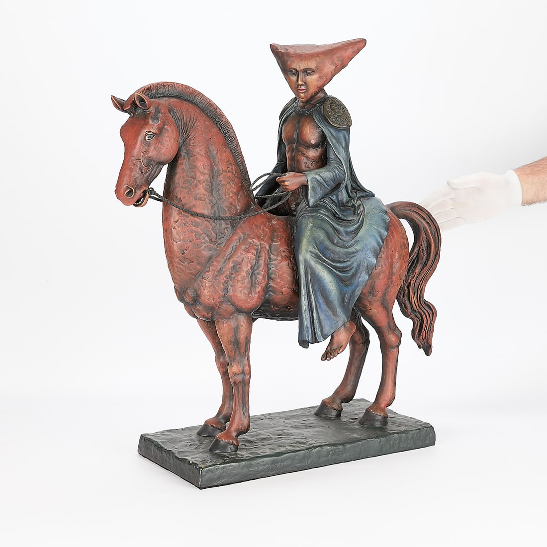 Sergio Bustamante Ceramic Equestrian Sculpture: Sergio Bustamante (Mexican, b. 1949). Large painted ceramic sculpture depicting a whimsical figure with sidelong and downcast gaze, riding astride a horse, 20th century. The figure surmounted by an an