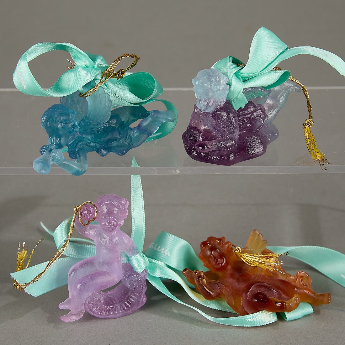 4 Daum France Pate-de-Verre Glass Angel Ornaments: Daum, France. Group of four French pate-de-verre crystal frosted art glass Christmas tree ornaments. All with branded boxes. Including:One "Angelot et Lyre (Angel and Lyre)" ornament depicting a cheru