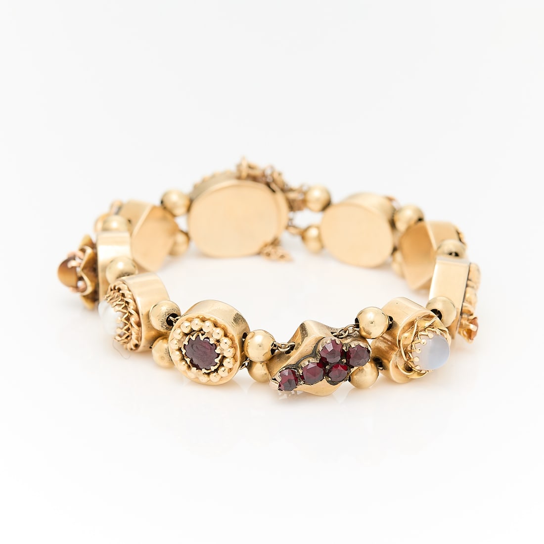 14k Gold Victorian Slide Bracelet: 14k yellow gold Victorian or Victorian revival slide bracelet comprised of two chains set with gold balls and slide charms set with garnets, citrine, moonstone, pearl, crysoberyl and a cameo. With a b