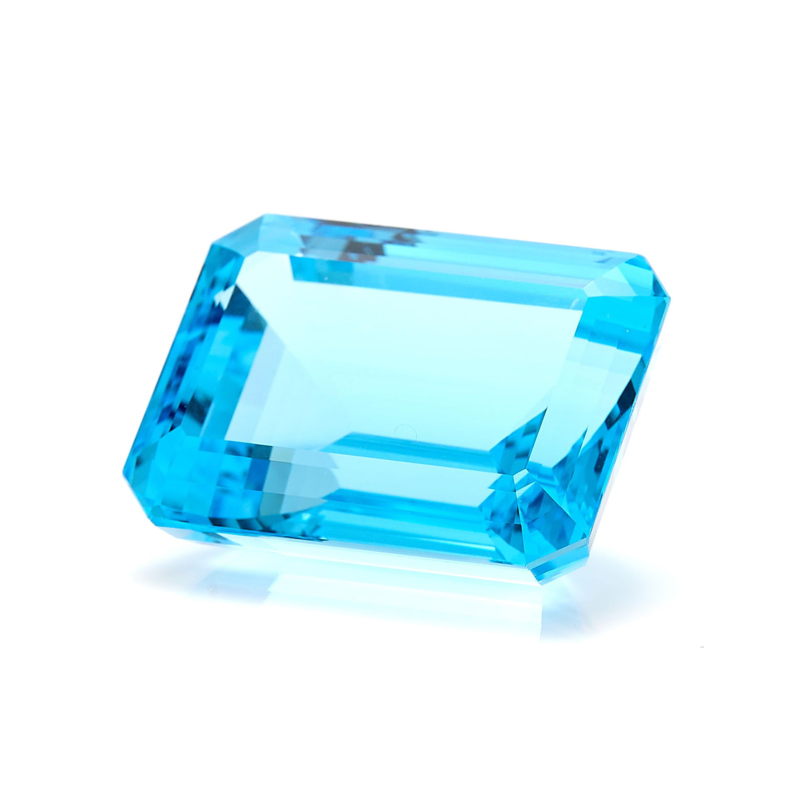 Step Cut Blue Topaz 122 CT: One step cut rectangular blue topaz of 122.85 ct.Length: 29.50 mm x width: 23.40 mm x depth: 16.34 mm. Gross weight: 122.85 ctw.