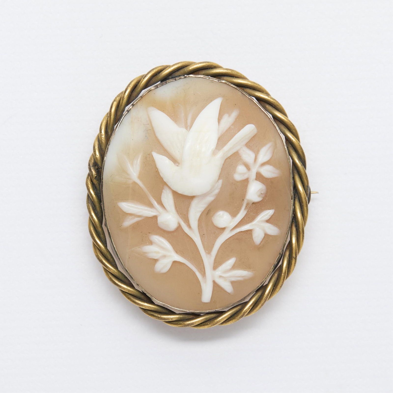 Cameo Brooch with Bird: Cameo brooch in base metal set with a cameo depicting bird in a tree, surrounded by a twisted frame. With locking closure.Height: 44.06 mm x width: 36.82 mm x depth: 15.28 mm. Gross weight: 10.2 g.