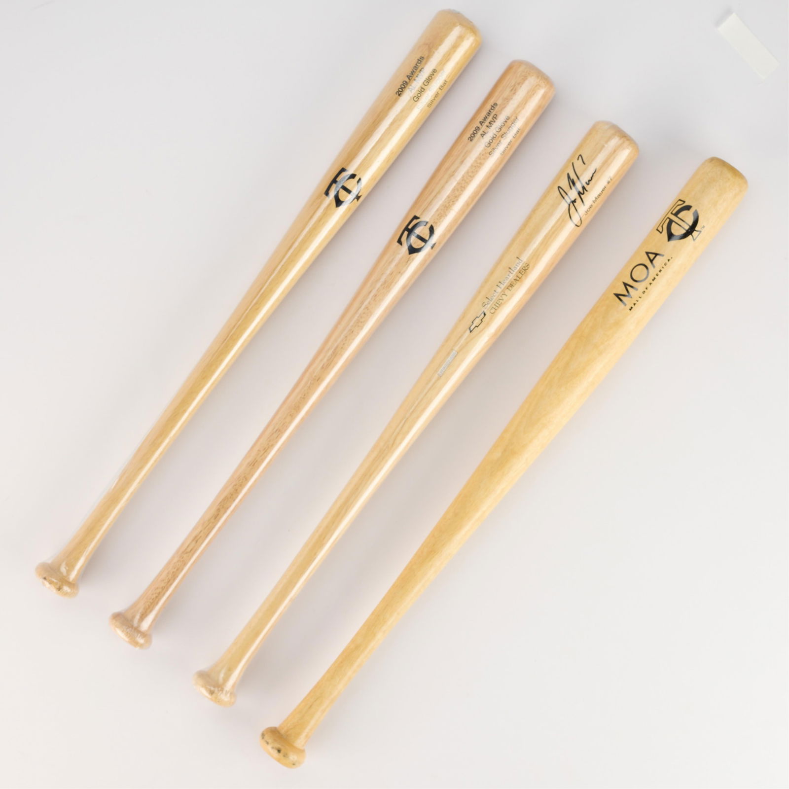 4 Joe Mauer Promo Bats: Group of four Joe Mauer promotional bats. Branded signature. Three sealed in plastic. (Sealed bats, each) length: 28 in x diameter: 2 1/2 in. (Unsealed bat) length: 30 in x diameter: 2 1/2 in.