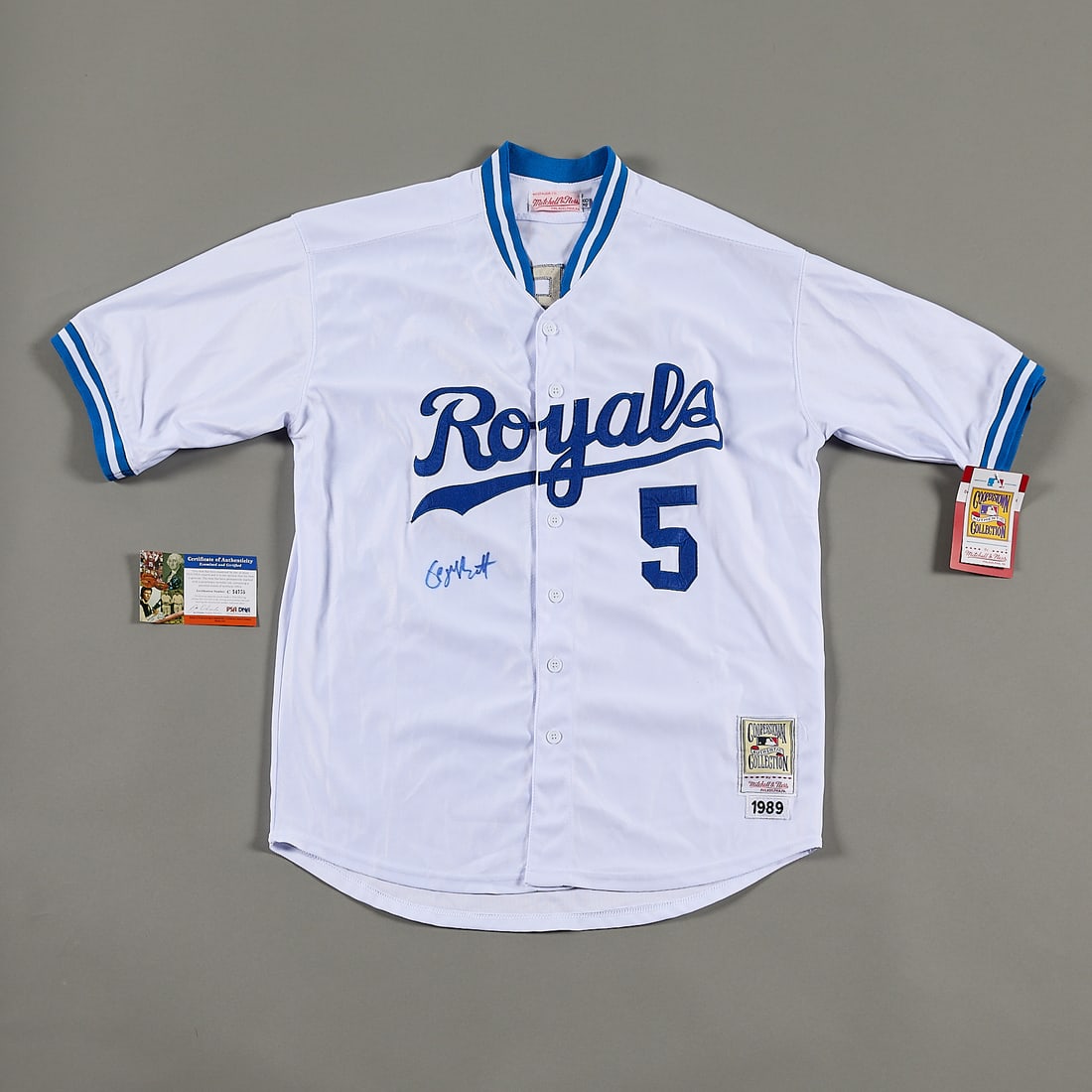 George Brett Signed Royals Jersey PSA: George Brett autographed Royals jersey. Signed in blue ink below the team name on the front of the jersey. PSA/DNA: C54755. The jersey is a Mitchell & Ness Cooperstown Collection Royals jersey. Size: