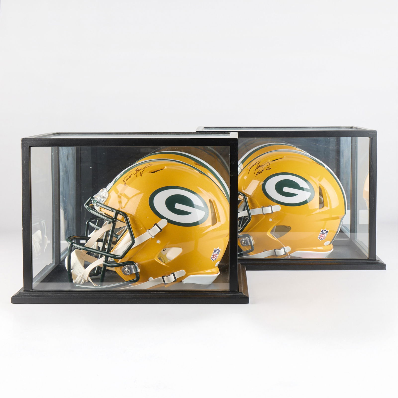 2 Signed Brett Favre Helmets JSA: Group of two autographed Brett Favre authentic large full-size football helmets. JSA certified: BB05783 & BB05782. Both signed in black ink. Both helmets with mirrored and glass display cases.