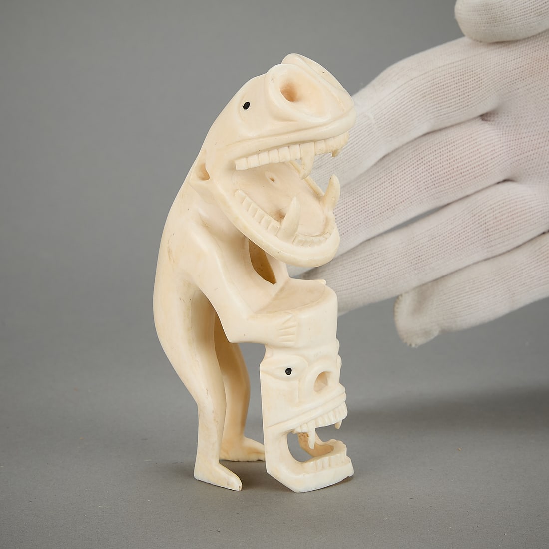 Kalaallit Inuit Tupilak Figural Carving w/ Faces: Kalaallit (Greenlandic Inuit) carved organic material figure depicting a standing tupilak (tupilaq) with two faces.Provenance: Heard Museum, Arizona; Private Collection, New York.Height: 5 1/2 in x wi