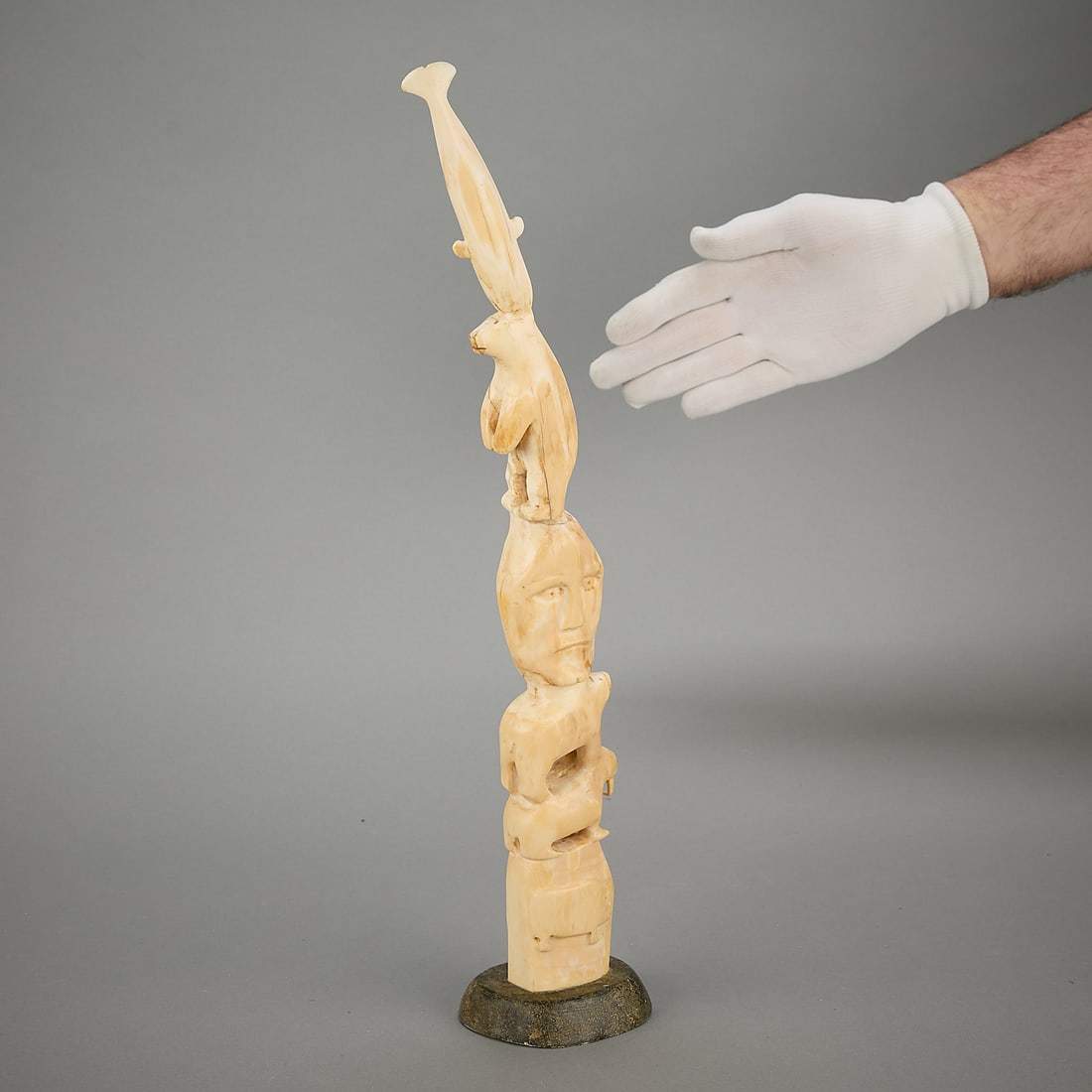 Mark Tungilik Carved Animal Totem ca. 1980: Mark Tungilik (Inuit (Naujaat - Repulse Bay), 1913-1986). Carved organic material totem pole figure depicting layered and stacked arctic animals and additional life forms with shaman's faces along the