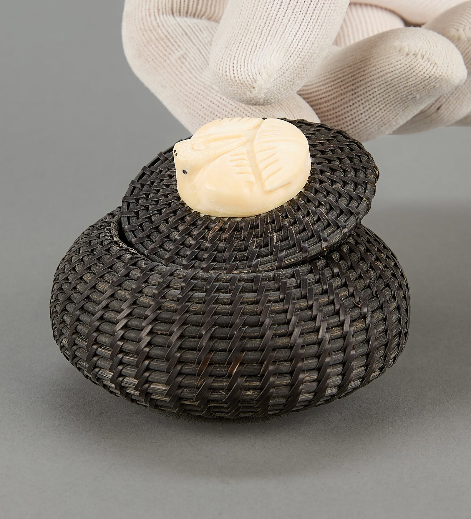 Small Sheldon Bogenrife Woven Basket: Sheldon Bogenrife (Inupiaq (Ulguniq - Wainwright), b. 1953). Small basket woven from organic material with carved organic material finial in the form of a mammal, ca. 1997.Provenance: Collection of Dr