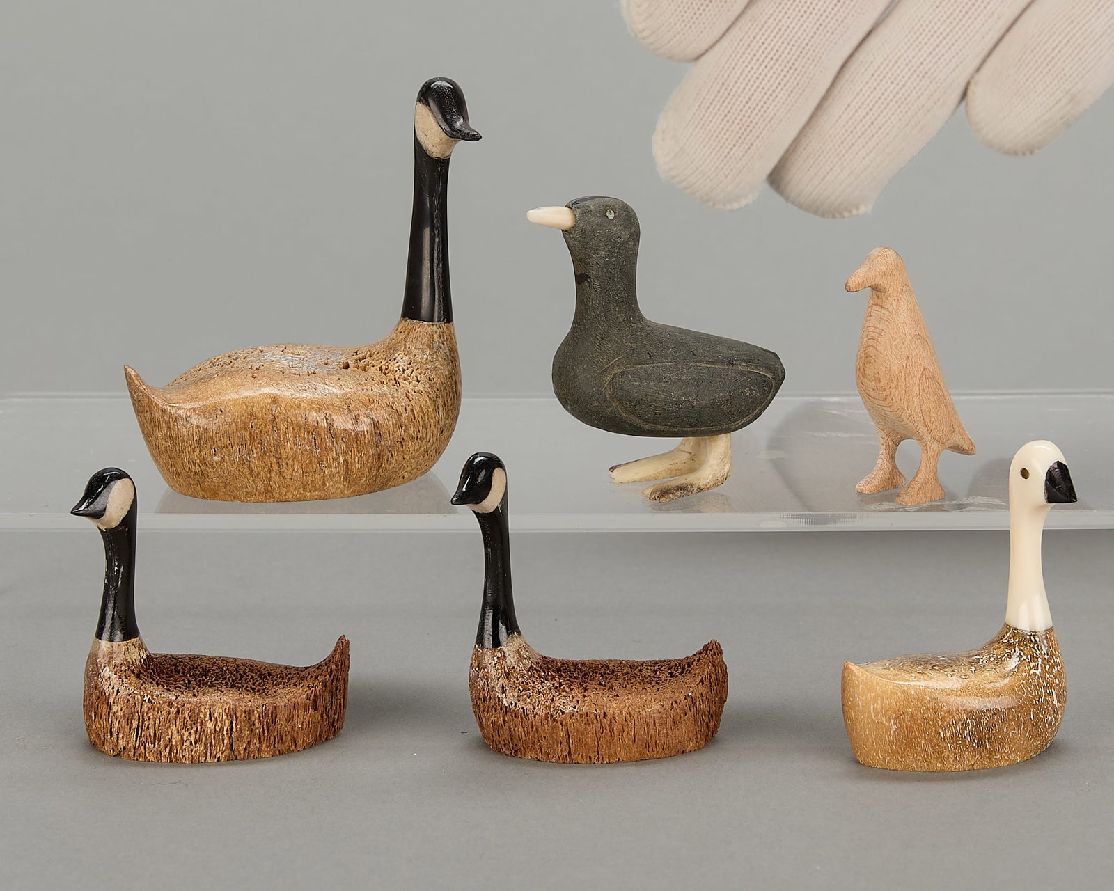 6 Inuit Miniature Carved Birds: Group of six diminutive carved birds, including: Four Chris Aningayou (Yupik, b. 20th century) carved organic material birds (three Canadian geese, one gold eyed goose). Each signed in marker along