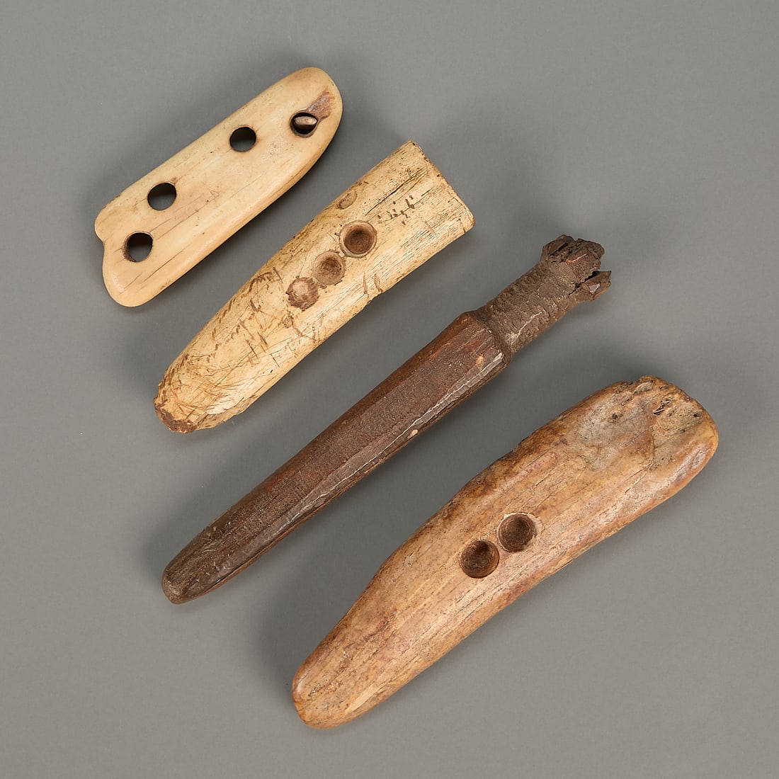 4 Assorted Inuit Tools: Group of four Inuit carved organic material Thule or Bering Sea culture tools, including three fire starters and a long cylindrical implement with a handle (possibly drum beater).Provenance: Purchased