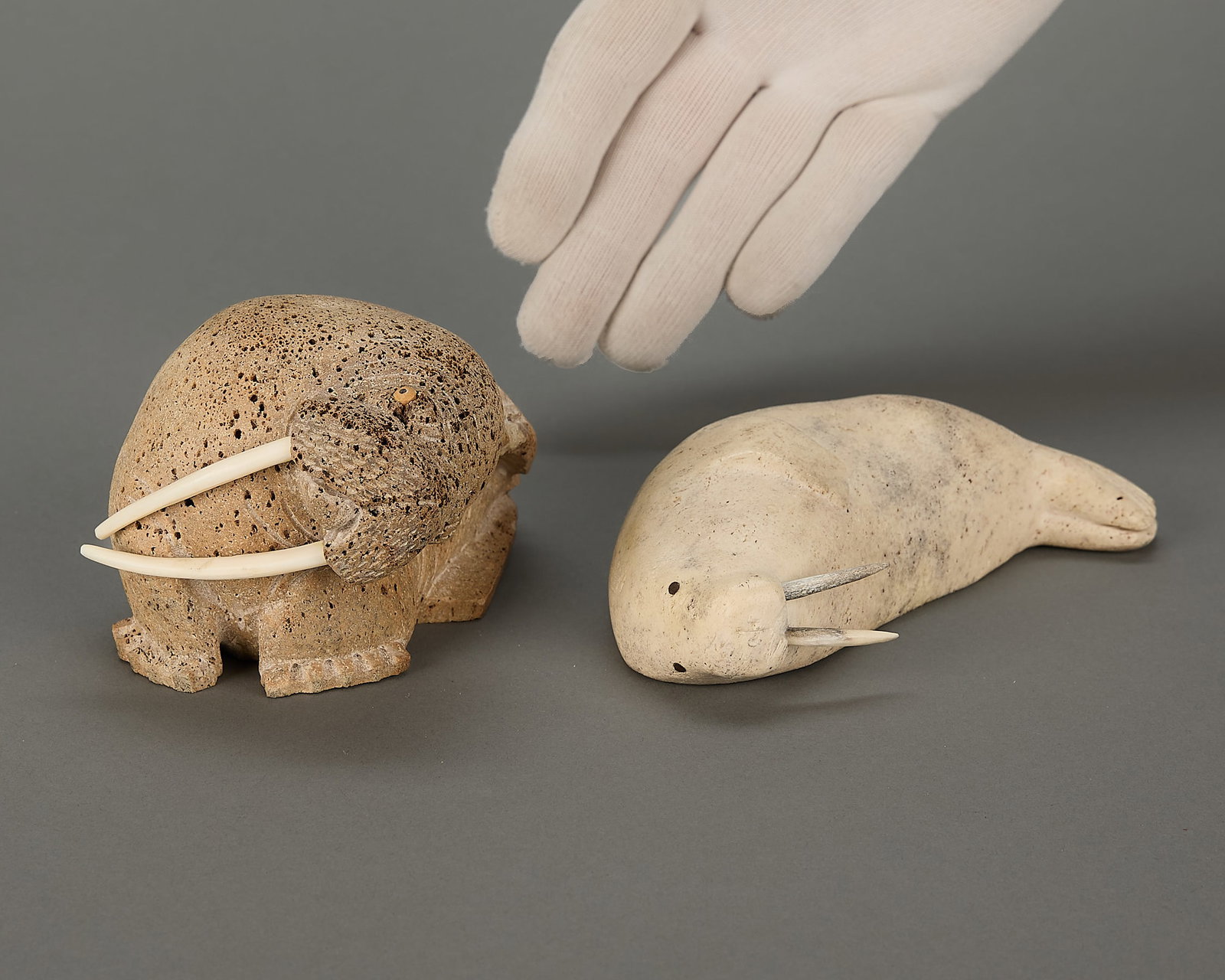 2 Inuit Carved Arctic Mammals: Group of two Inuit carved organic material mammals, including one by Tom Akeya circa 1999 and one by Peter Ahloolooo circa 1972. Both signed along the base.Provenance: Heard Museum, Arizona; Private C