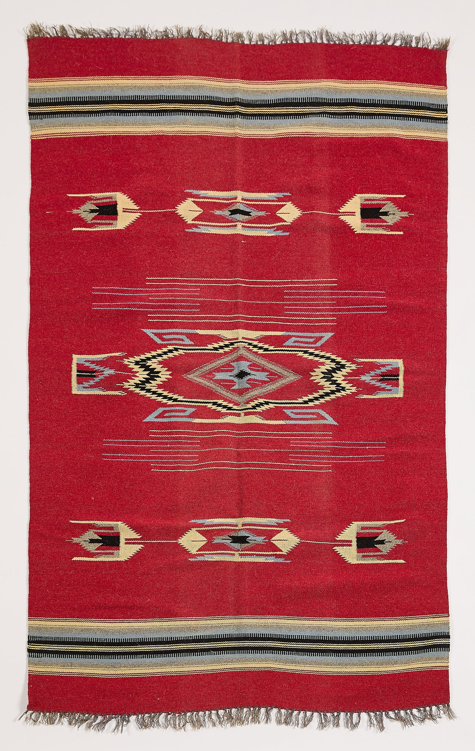 New Mexican Chimayo Blanket 5'10"x3'8": Southwestern Native American style New Mexican "Chimayo" blanket or rug textile, 20th century. The carpet with central field depicting serrated and curled geometric forms, flanked by bands of blue, cr