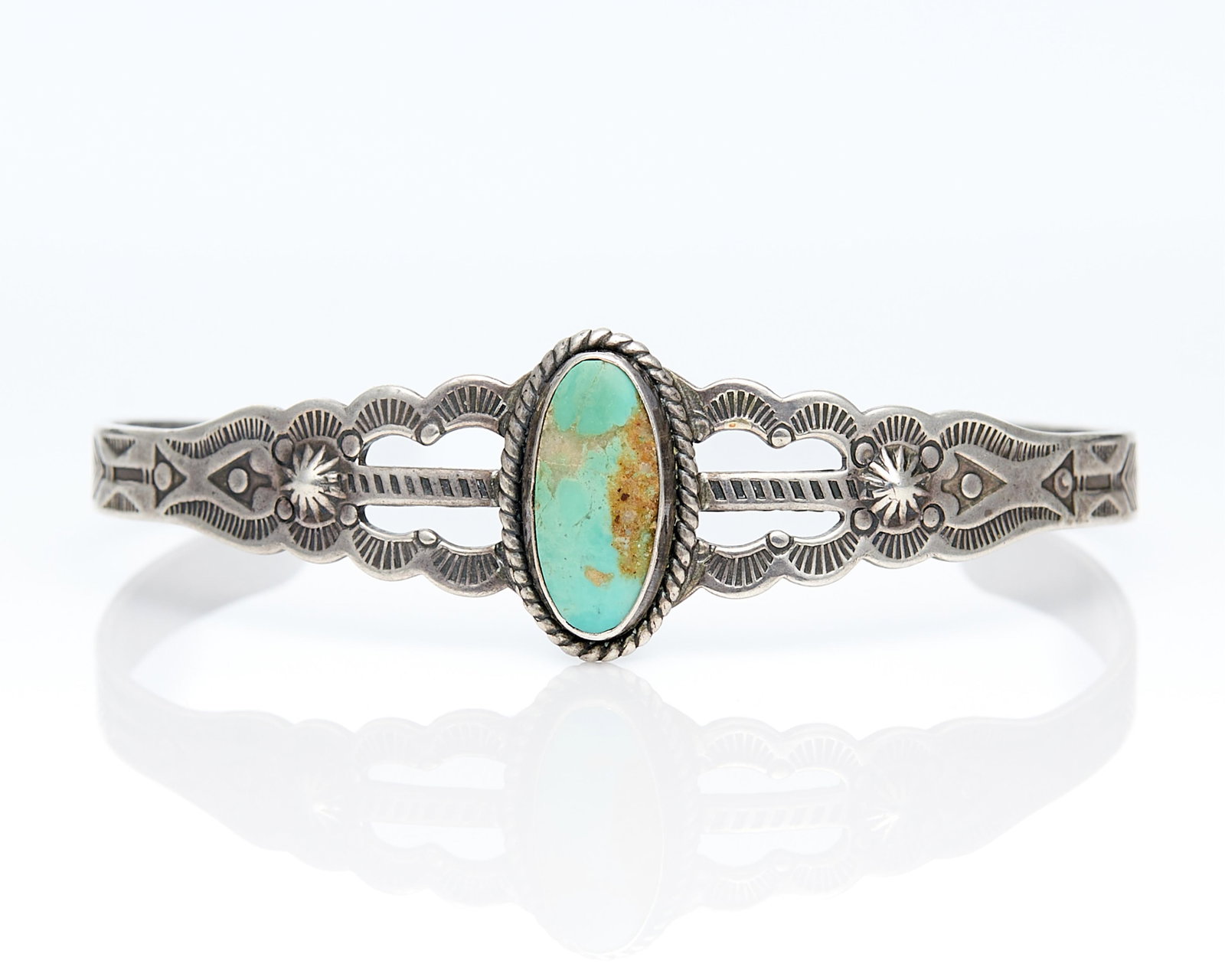 Harvey Style Sterling Cuff Bracelet: One Harvey style sterling silver cuff set with oval turquoise cabochon. Marked sterling along the interior.Inner diameter: 2 1/4. Gross weight: 9.0 g.