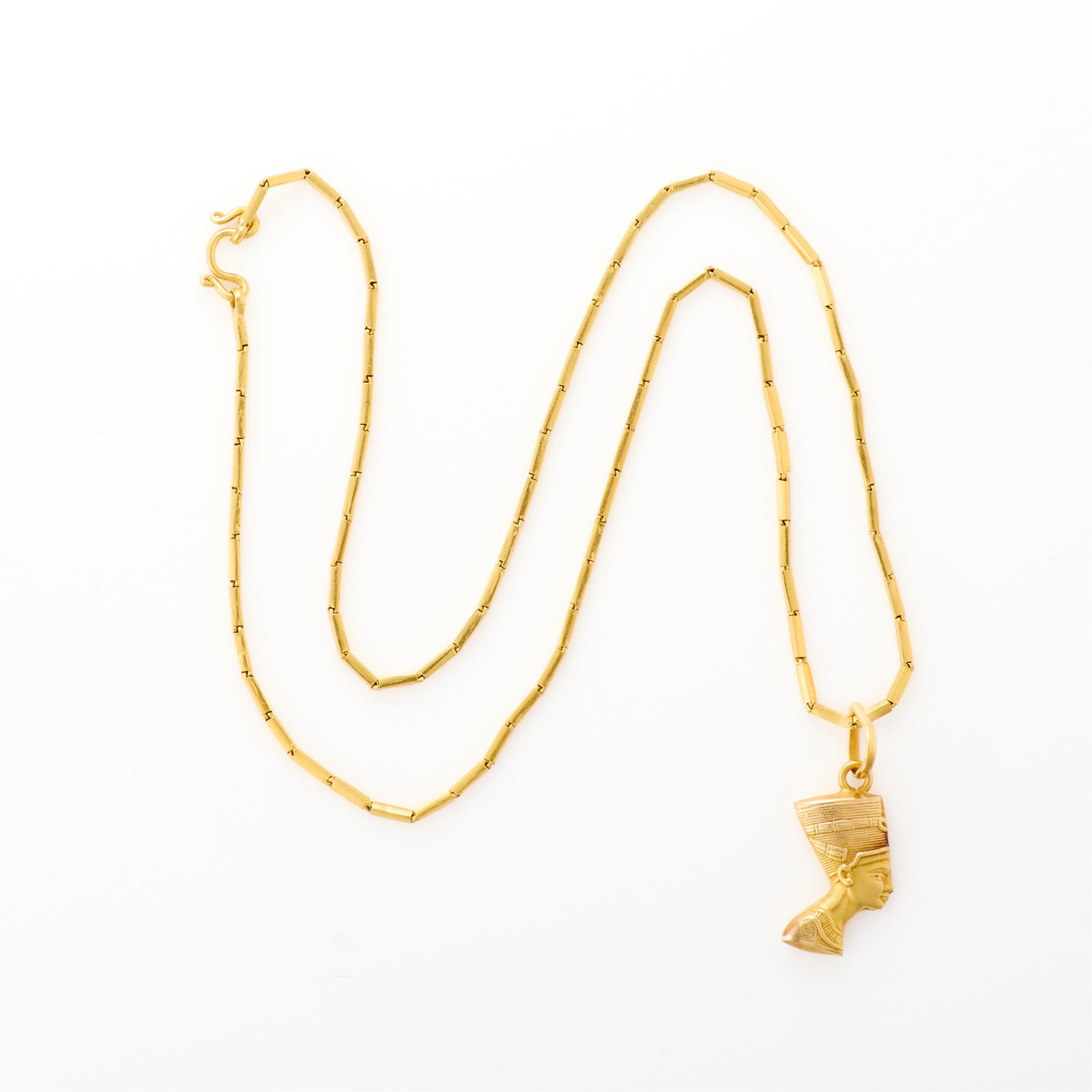 Gold Trombone Chain & Nefertiti Pendant: Yellow gold trombone chain with hook and eye clasp. Unmarked, tested approximately 18k. With a hollow gold pendant of Nefertiti. Unmarked, tested approximately 18k. Length: 14 1/2 in. Gross weight: