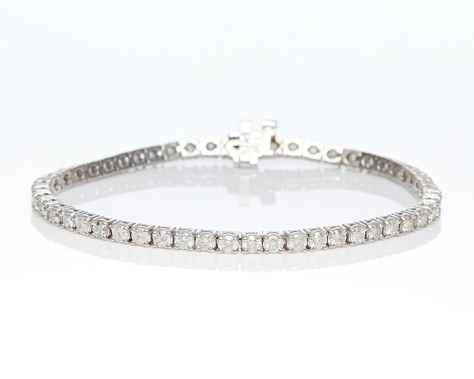 14k White Gold Diamond Tennis Bracelet - 5.00 ctw: 14k white gold diamond tennis bracelet set with 52 round brilliant cut diamonds of G-H color, SI2-I2 clarity, totalling 5.00 ctw. On a box clasp with safety latch. Marked 14k at the clasp. With GGA