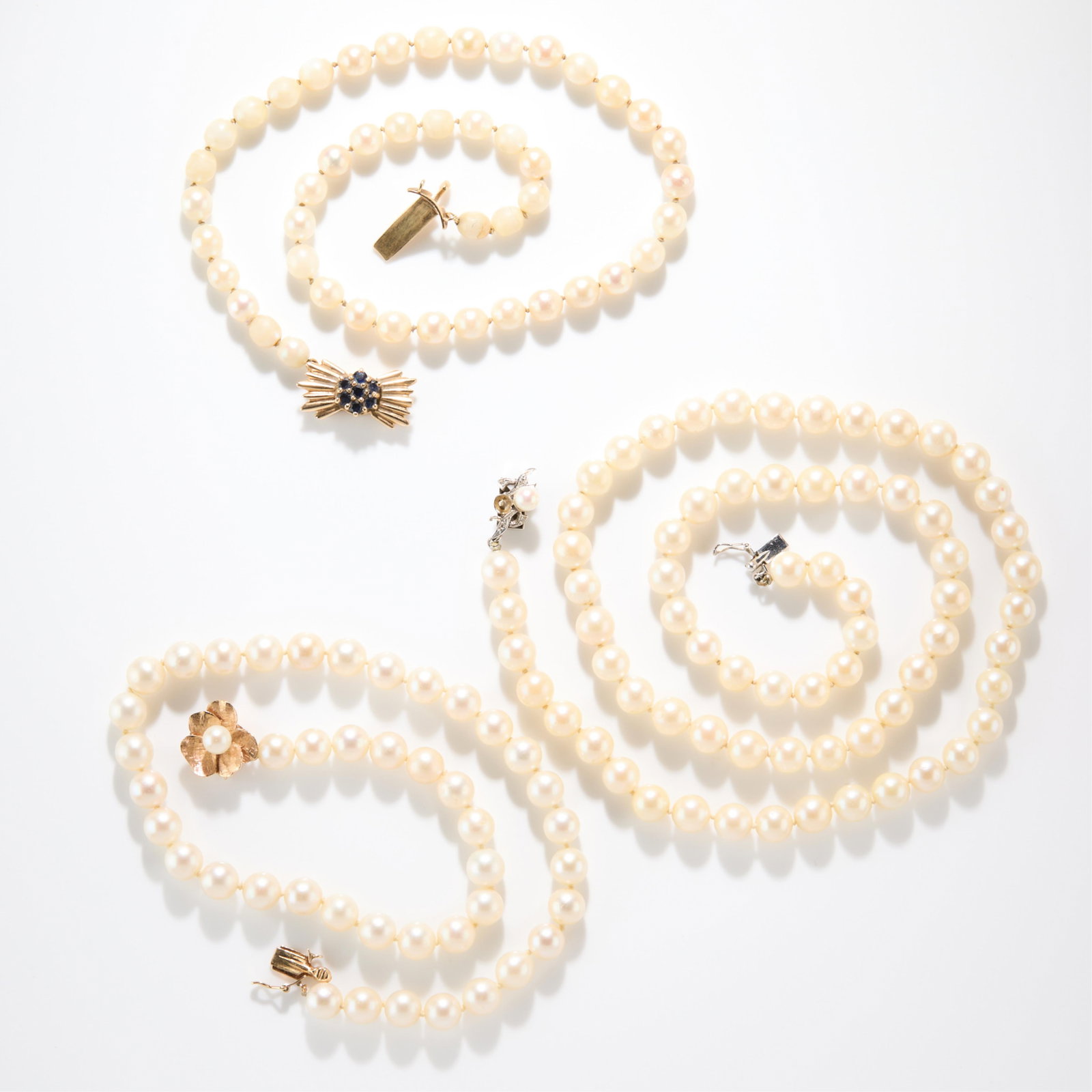 3 Strands 14k Pearls: Three strands of 14k gold clasp pearl strands, including one strand with 14k yellow gold and sapphire bow form clasp, one strand with 14k yellow gold floral form clasp, one strand with 14k white gold,