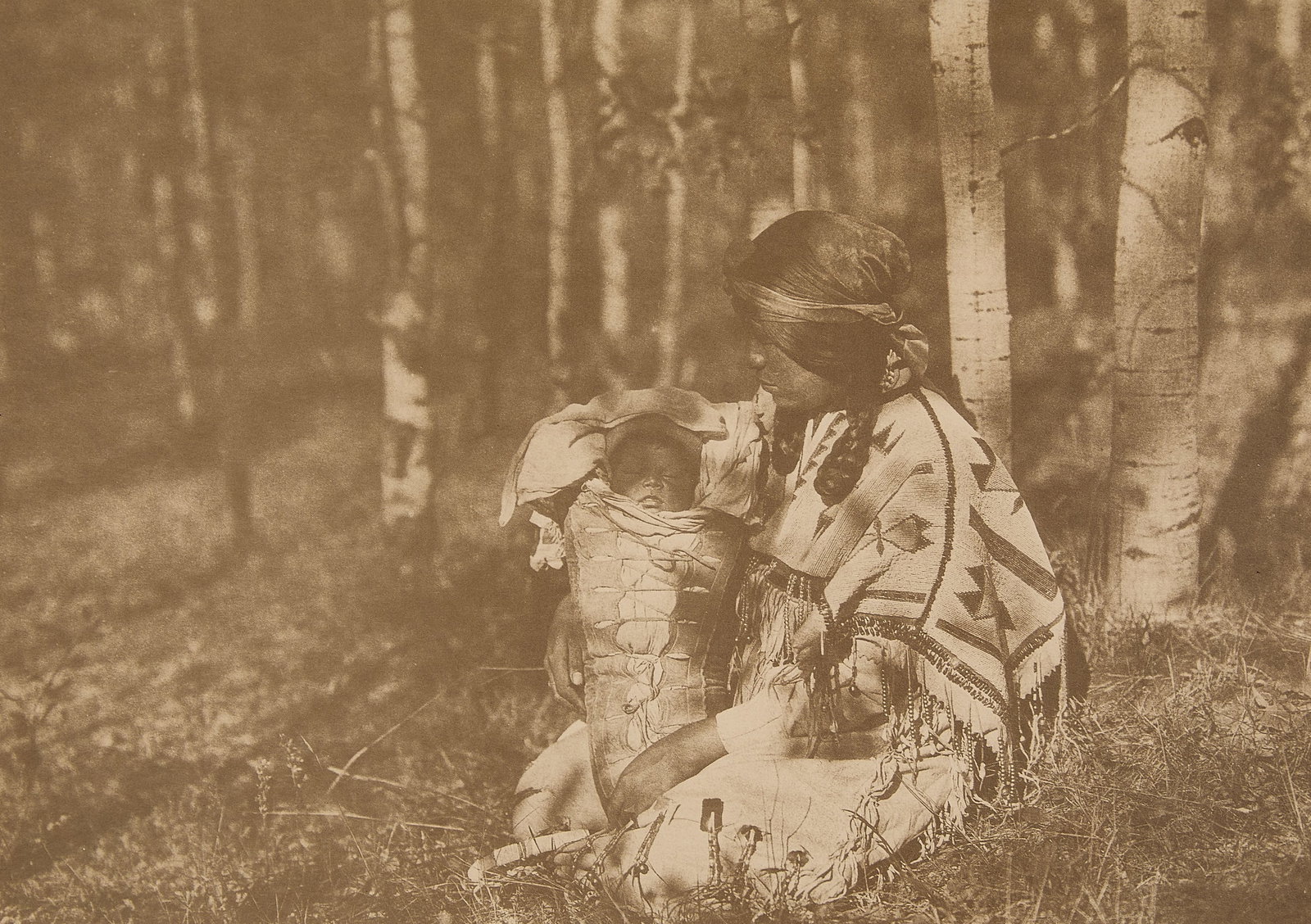 Edward Curtis "Mother & Child" Photogravure 1926: Edward Sheriff Curtis (American, 1868–1952). Photogravure titled "Assiniboin Mother and Child," 1926. Depicting a woman holding a swaddled child amongst a forested landscape. Signed, titled, and