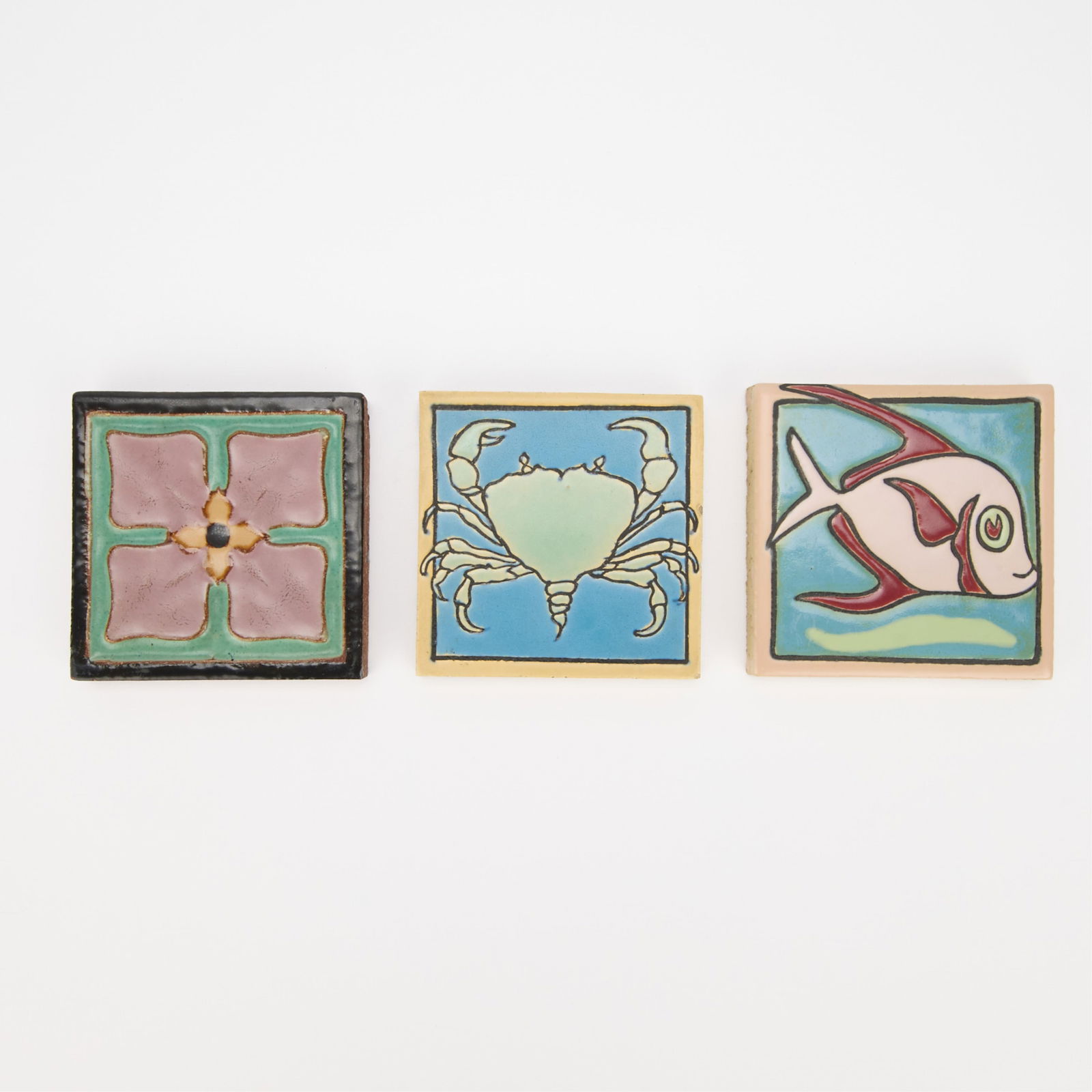 3 Mosaic Tile Co. Arts & Crafts Pictorial Tiles: Mosaic Tile Company, United States. Group of three ceramic Arts & Crafts pottery pictorial relief tiles, 20th century. Including: one tile depicting a crab, one tile depicting a fish, and one tile dep