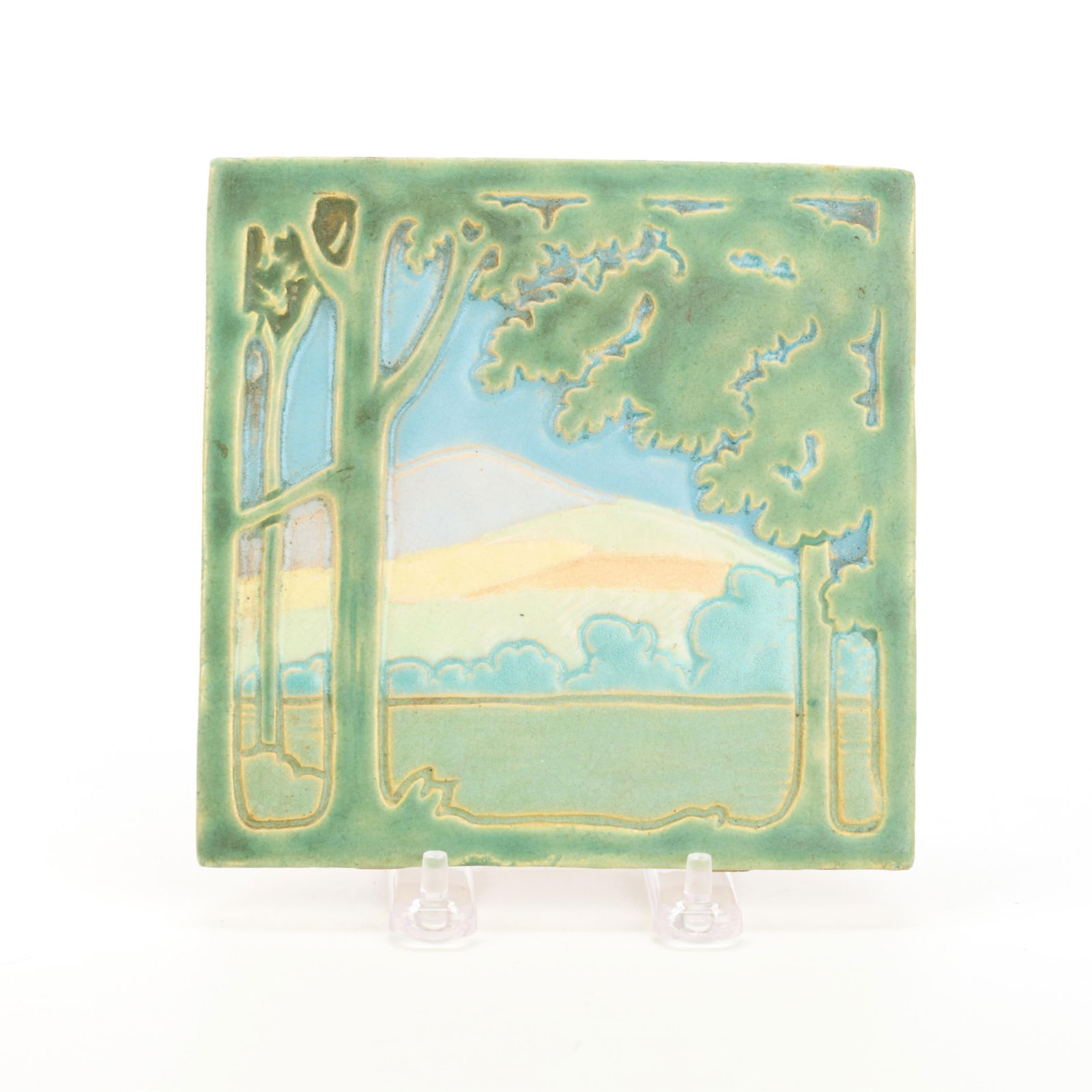 Rare Weller Art Pottery 8-Color Landscape Tile: Weller Pottery, Zanesville, Ohio. Rare eight-color ceramic pictorial relief tile depicting a forested landscape with mountains in the distance, early 20th century. Impressed "Weller Art Tiles" stamp a