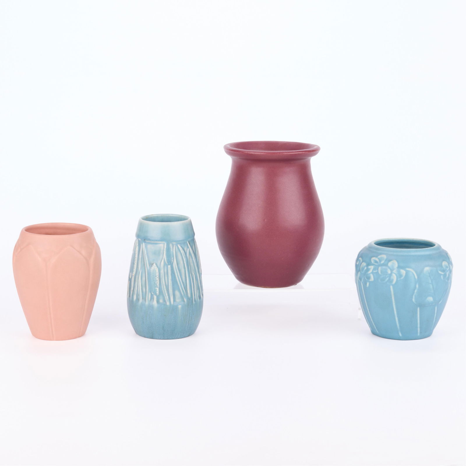 4 Art Pottery Vessels Incl. 3 Rookwood Vases: Group of four art pottery vessels. Including:Rookwood Pottery, Cincinnati, Ohio. One model no. "2592" vase, depicting molded cattails executed in a light blue glaze, 1929. Marked, dated, and numbered