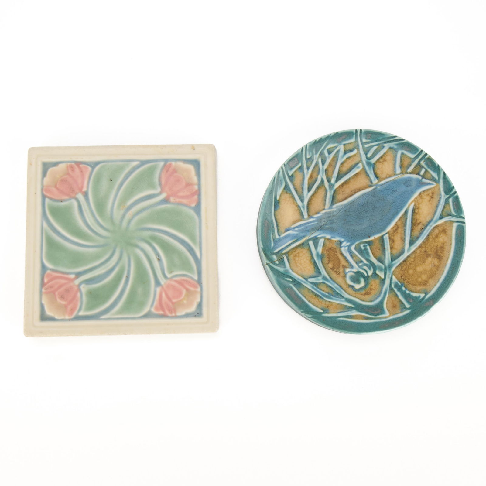 2 Early 20th c. Rookwood Art Pottery Trivet Tiles: Rookwood Pottery, Cincinnati, Ohio. Group of two Arts & Crafts pottery pictorial faience relief tiles, early 20th century. Including:One "2349" trivet tile depicting a raven or other bird perched on a